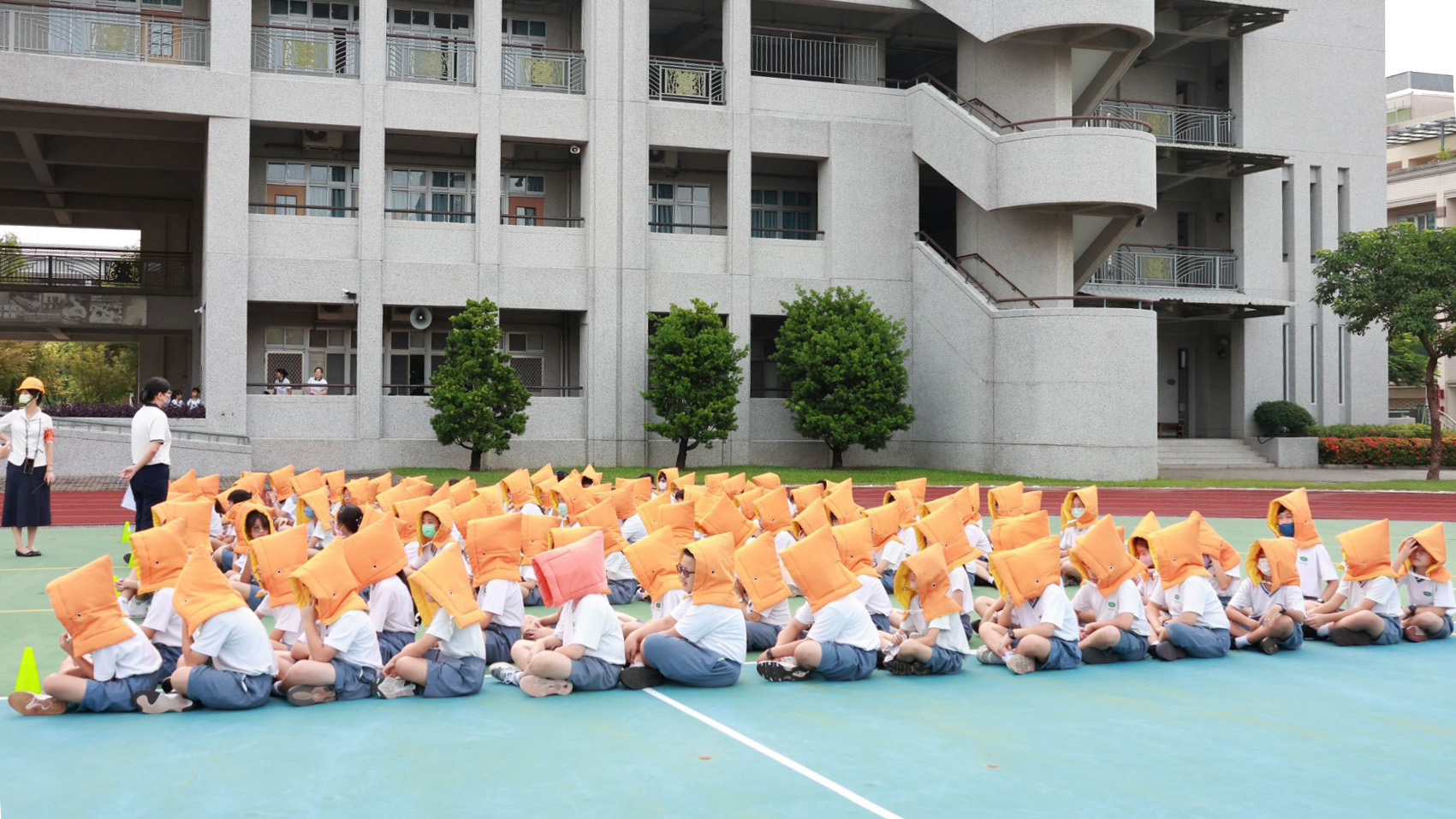 全校學生戴上防災帽，井然有序的在操場集合。