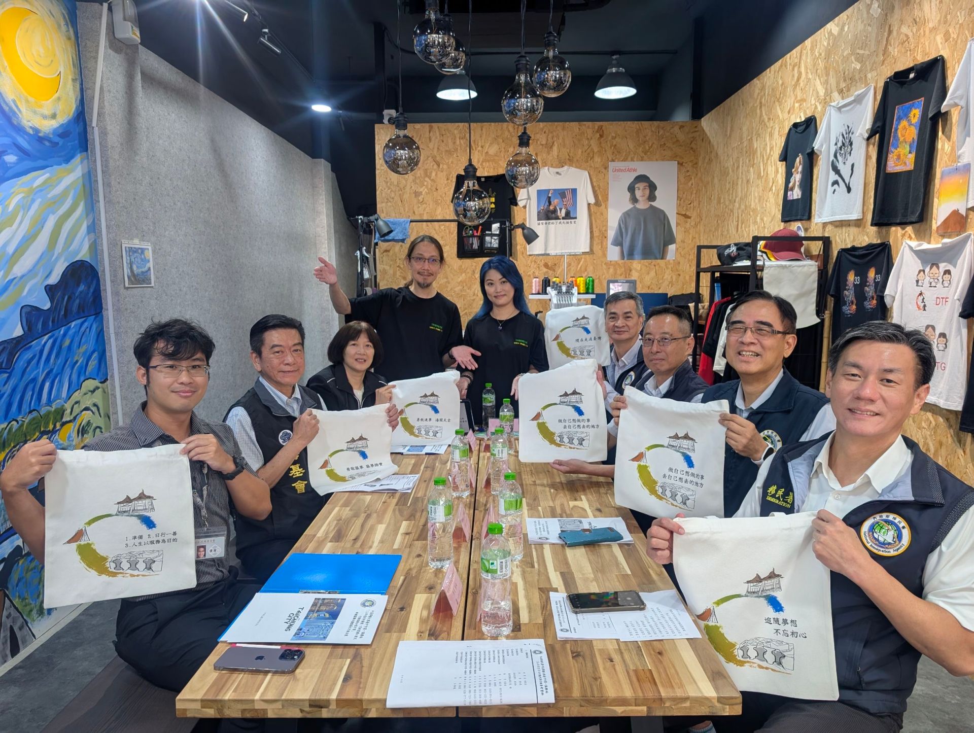 .移民署副署長陳建成(右4)率中區事務大隊大隊長徐靜儒(右3)、臺中市第一服務站主任王驥(右2)，偕同陸委會參事楚恆惠(左3)、海基金會顧問張峯青(左2)等人拜會來自香港的吳海文夫妻一起製作充滿愛與温度的手提袋