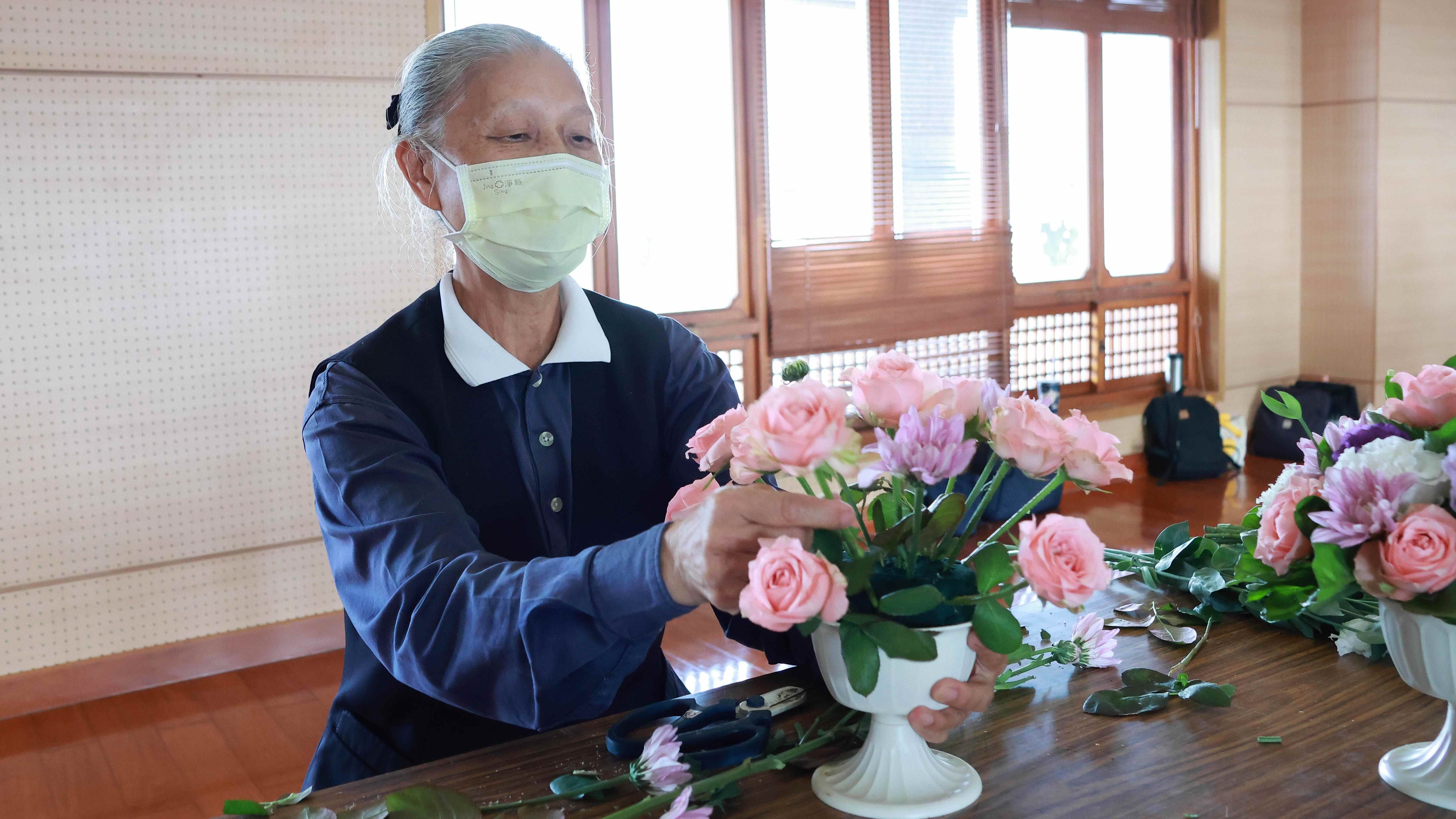花道志工協助插班級桌花，是對老師的一份支持。
