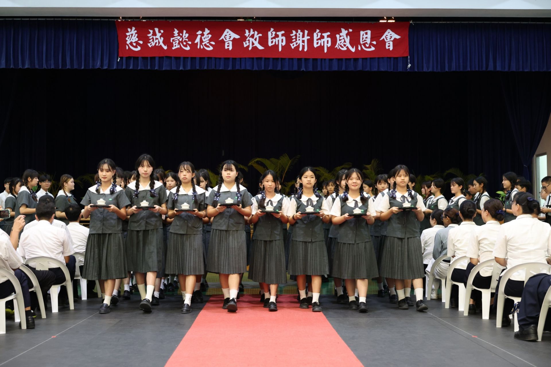 學生慎而重之，踏著一致的步伐，將手中一杯杯無聲的感恩奉給師長