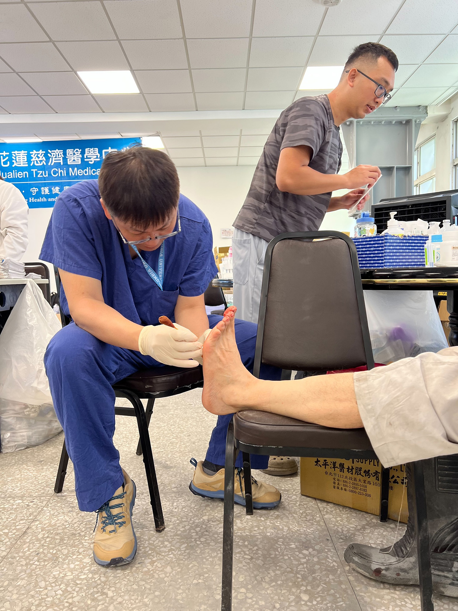 花蓮慈院一般外科主任陳言丞與骨科陳林睦醫師為傷患縫補腳上的傷口。