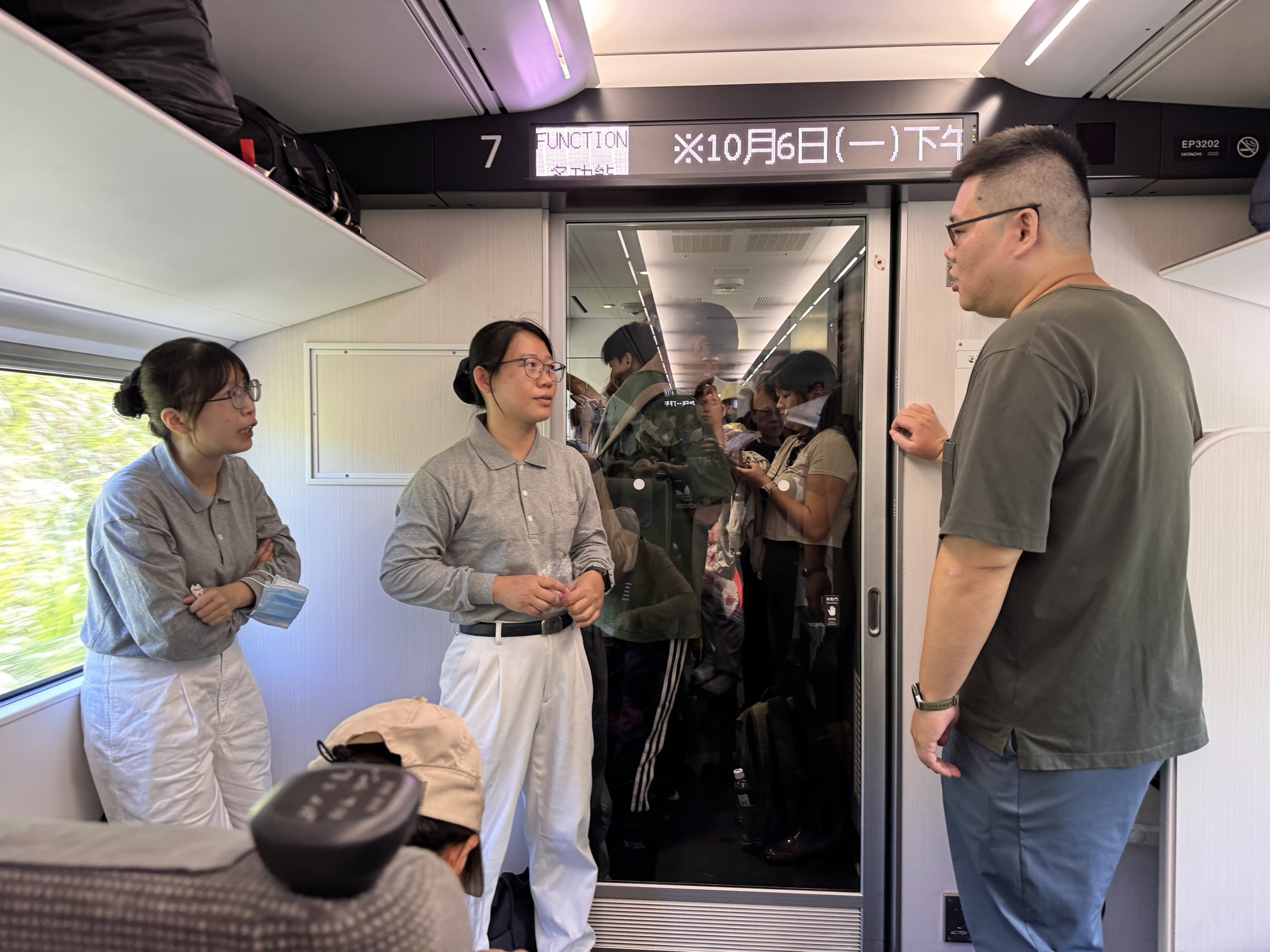 林昱汝秘書（圖中）與陳柏伶主任（圖左）在火車上與前往光復的年輕人分享救災經驗，也結緣寶礦力沖泡包，為年輕人加油！