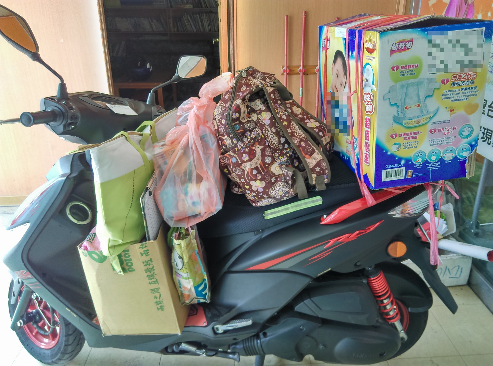 小小一台機車，前後堆滿紙箱、尿布等物資，幾乎沒有多餘空間。玟瑗仍想辦法把滿滿的物資送進每一戶服務家庭。
