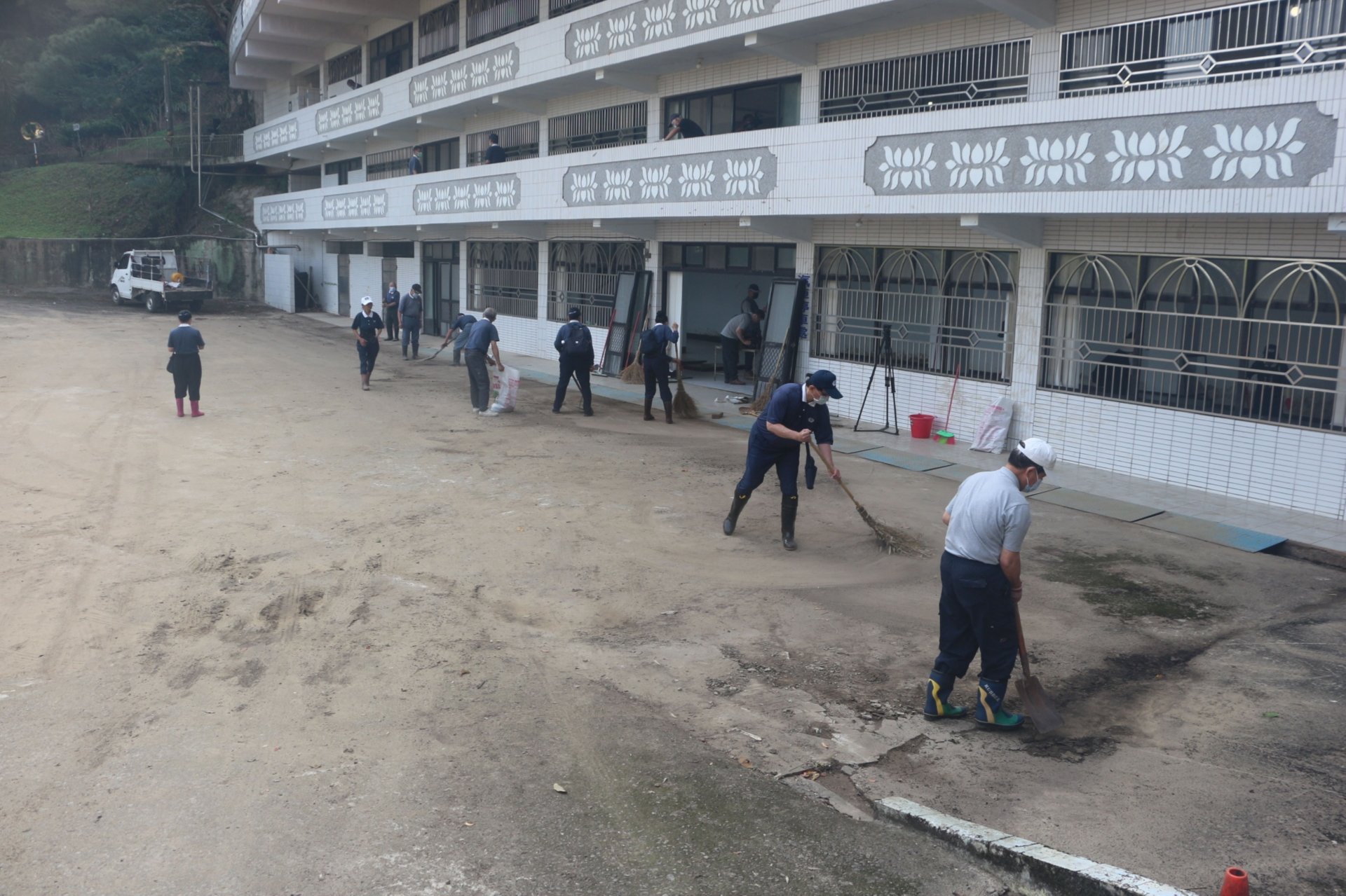 志工分工合作進行普光寺環境清掃,合力清除淤泥與積水。