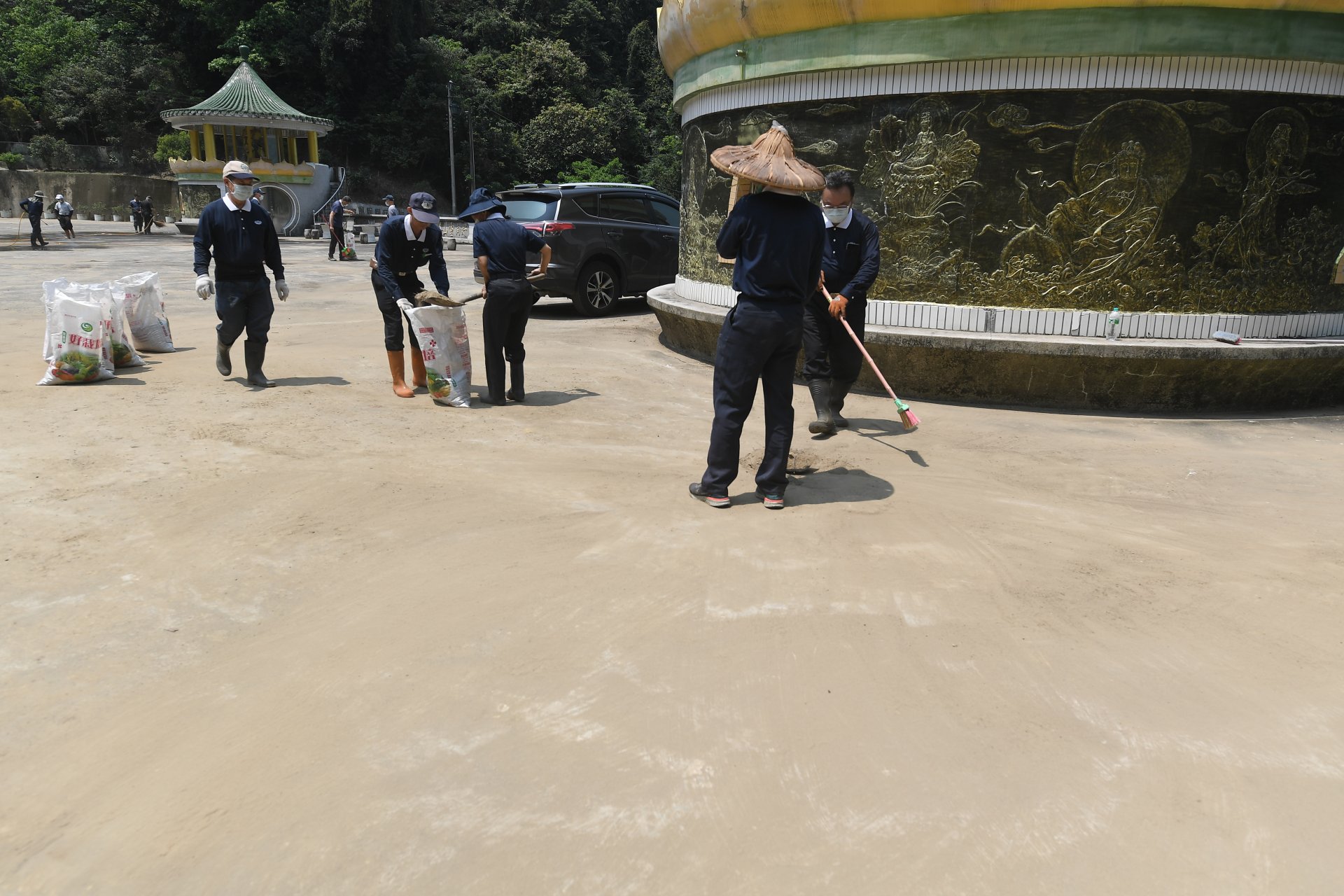 志工們在炎熱氣候下,持續清掃普光寺前廣場,揮汗投入、不畏辛勞,為恢復環境整潔默默付出。