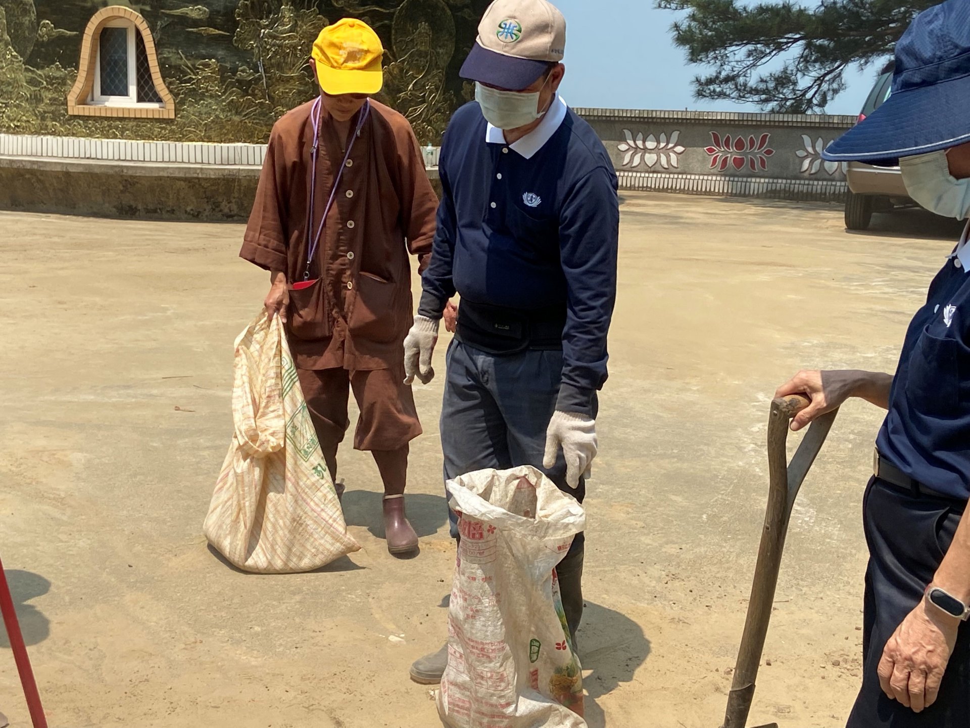 普光寺住持演定法師與志工們一同投入寺前廣場清掃工作。