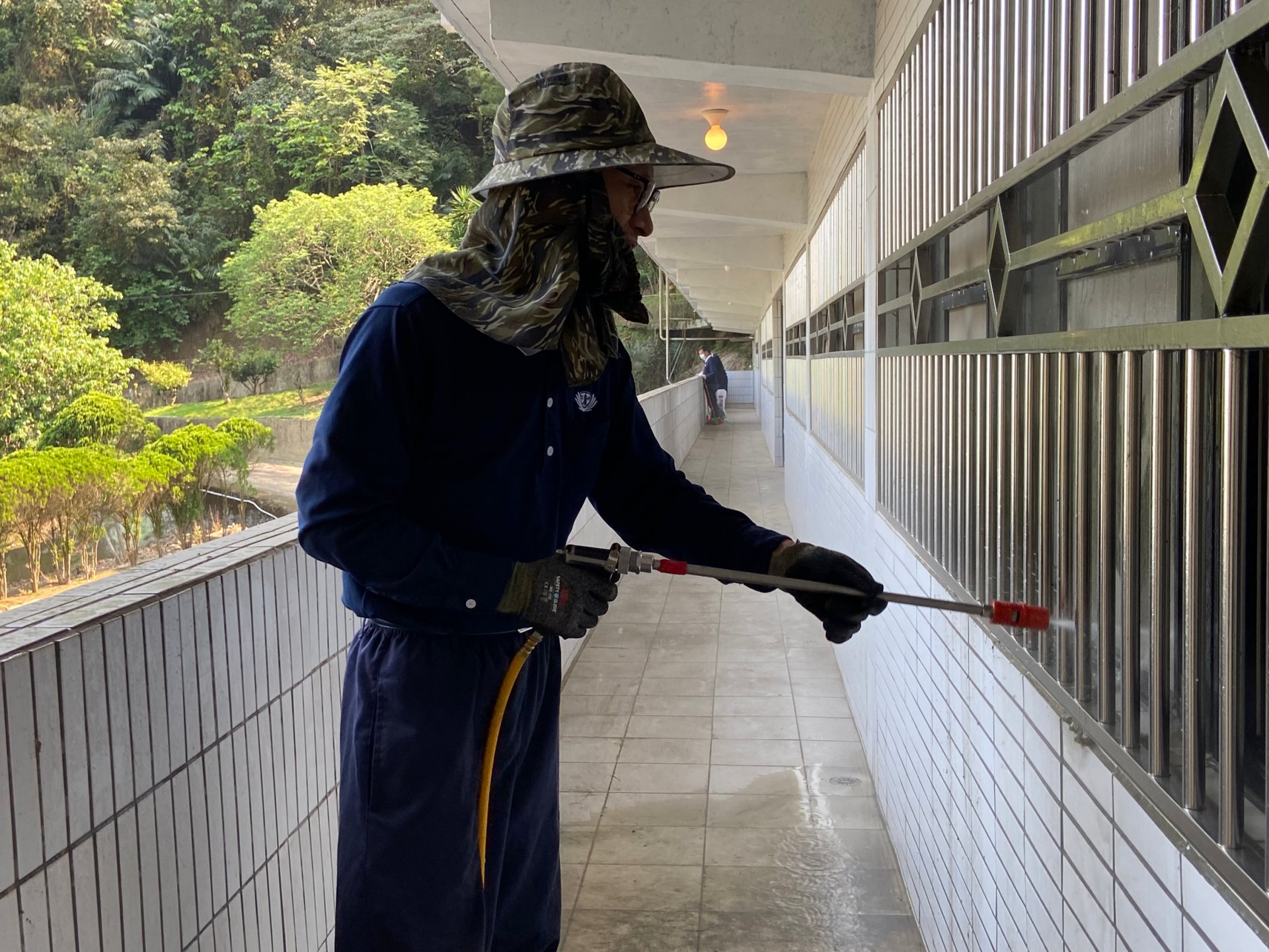 志工曾光華以高壓水槍清洗窗戶與地面。