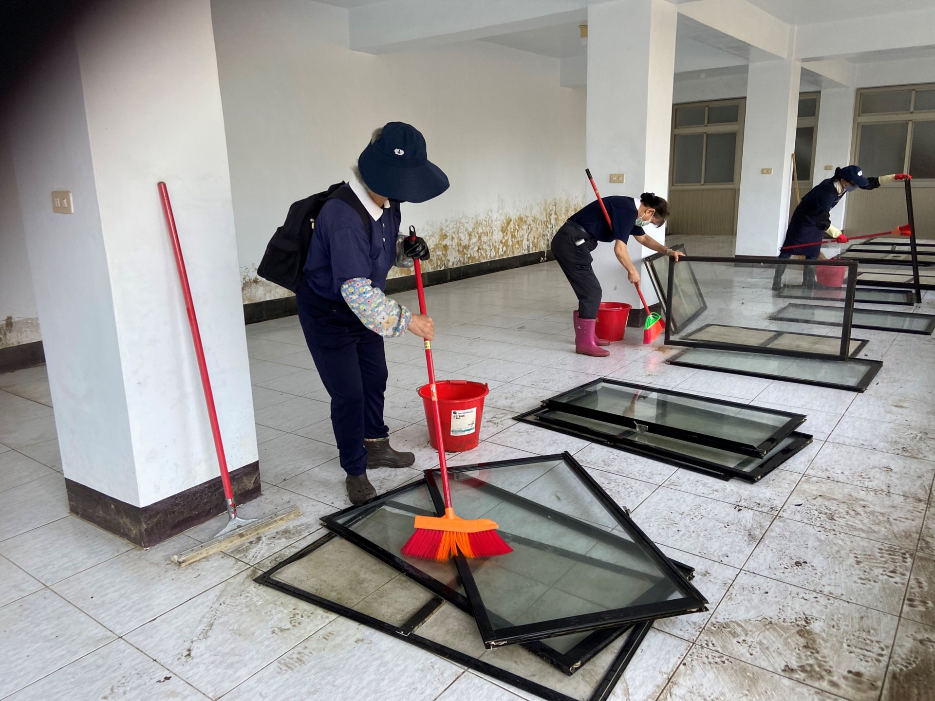 志工們合力清洗窗戶,仔細刷洗、沖淨污垢,讓窗面逐漸恢復明亮潔淨。