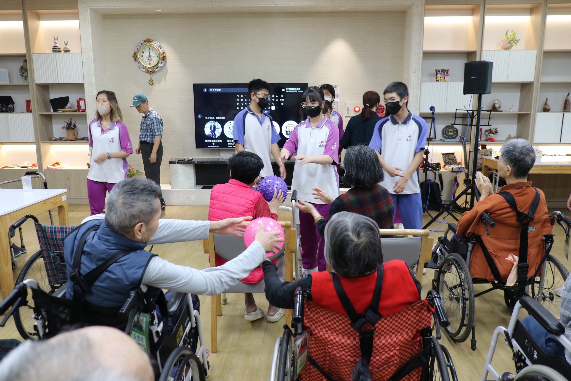 學子於住宿區帶領長輩進行傳球遊戲，活絡長輩認知與手眼協調，現場洋溢老幼共融的溫馨歡笑。