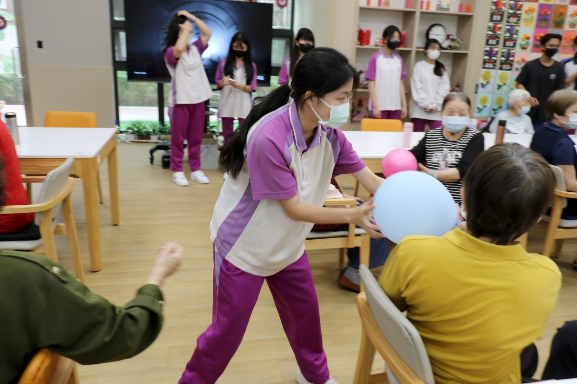 廖同學（中）與長輩互動傳球，在溫暖陪伴中，深刻體會長照服務無可取代的人性溫度。