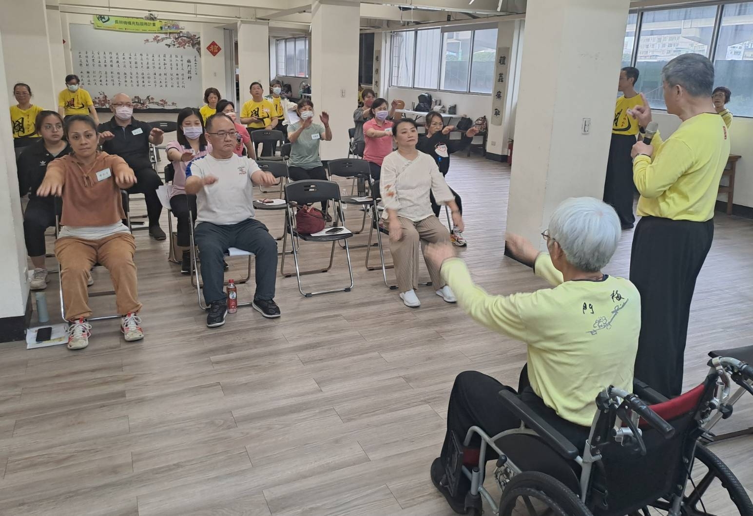 梅門師兄李志恆（右1）培訓長照機構負責人 示範教導如何讓坐輪椅者也可以運用上肢平甩 以改善身心健康