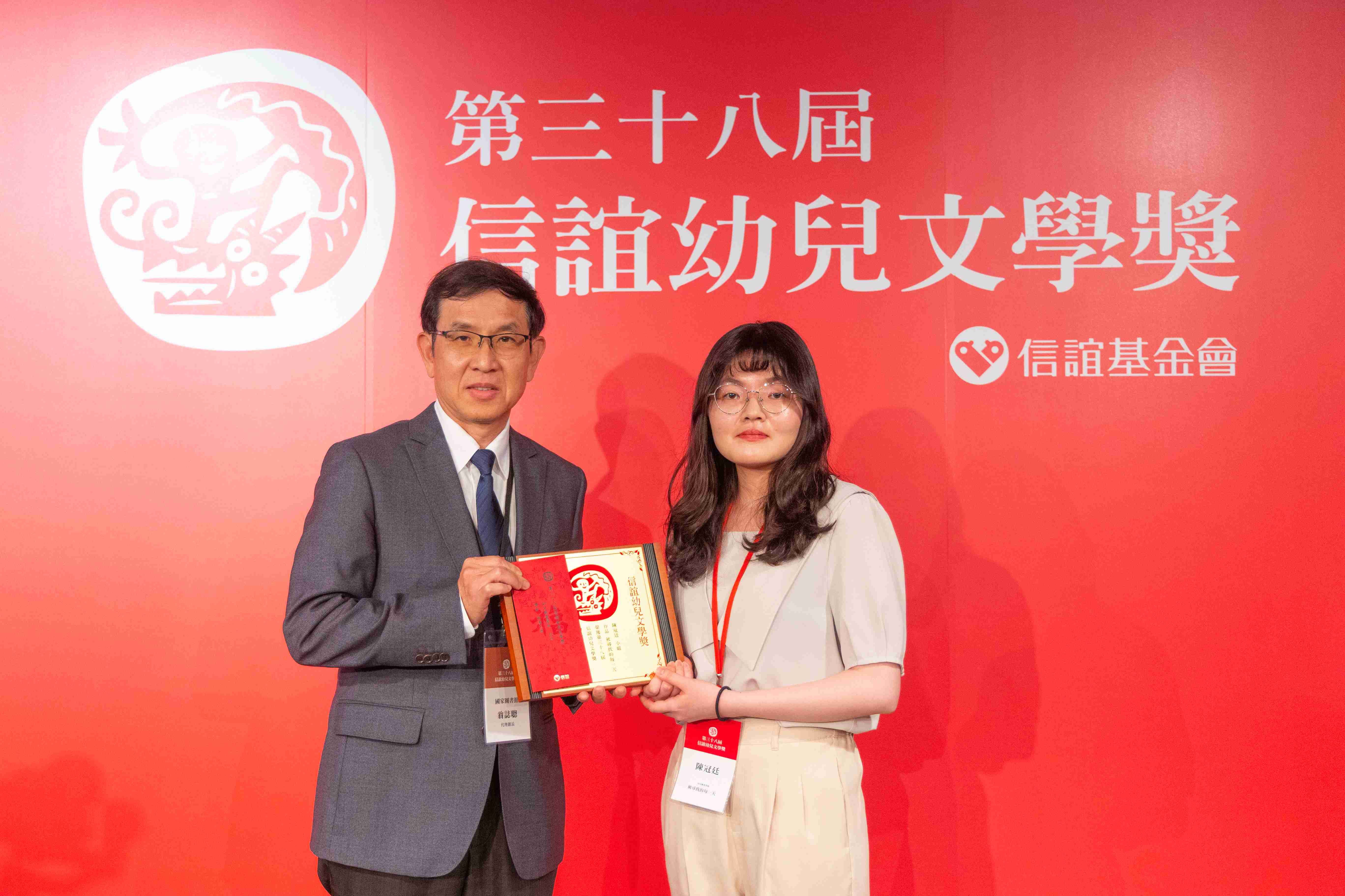 國圖翁誌聰（左）代理館長理頒發圖畫書佳作予25歲的創作者陳冠廷(右)。