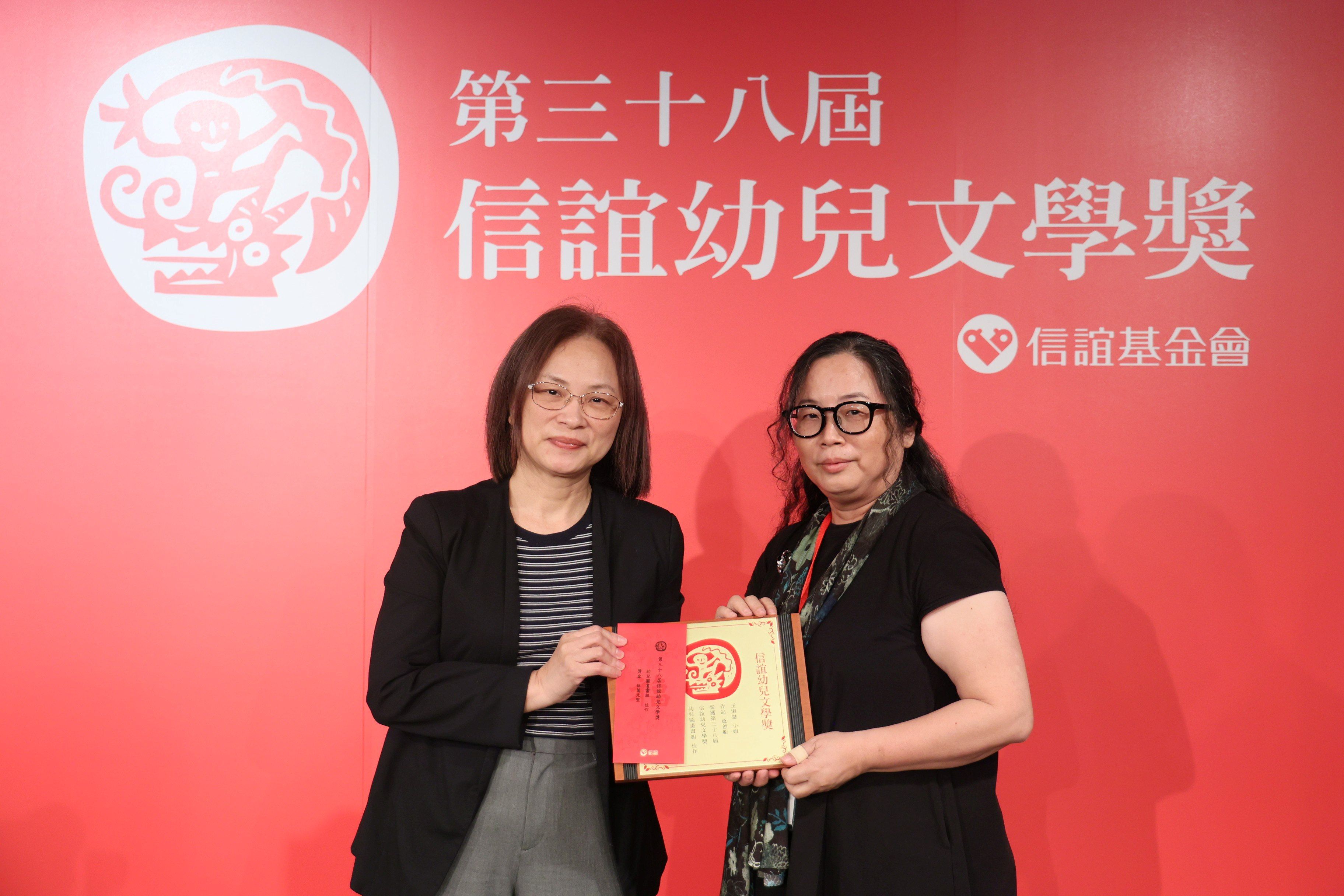 文化部人文及出版司鄧美容司長(左)頒發幼兒圖畫書組佳作予《爸爸船》王淑慧(右)。