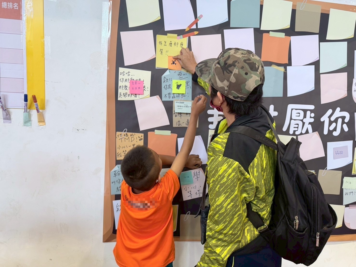 親子在「我討厭你」牆上，以正向與鼓勵語句取代傷人話語，透過實際行動學習同理與尊重他人。