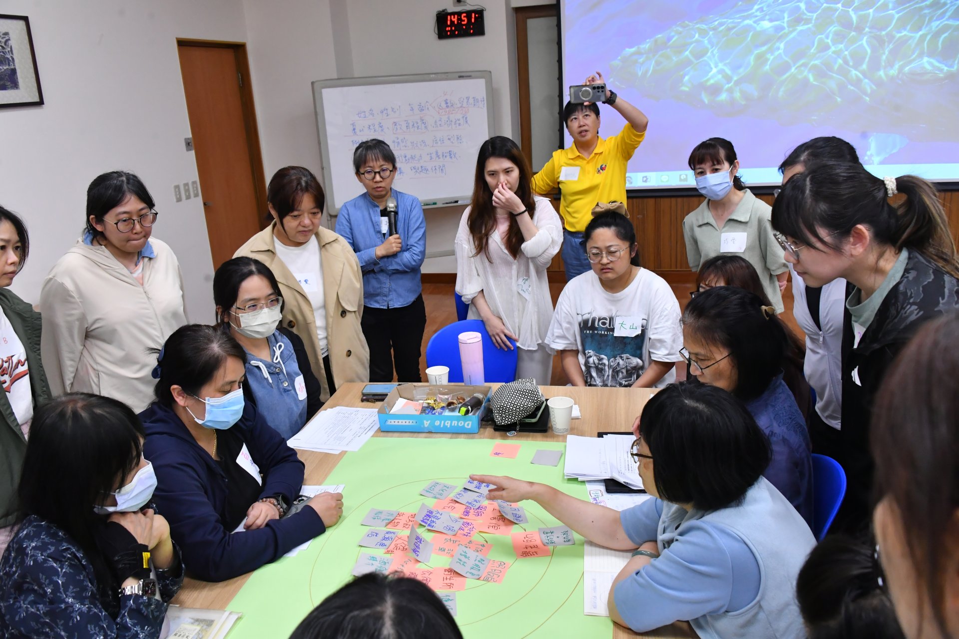 工作坊藉由團隊共同發想與討論，用便利貼和圖畫來幫助團隊了解提案重點並建立默契並覺察不同觀點與方法，也藉此培養社會處方箋促進成員的同理心、感性和彈性。圖為學員們共同聆聽「山林文化與健康行為社會處方箋計畫」團隊的設計構想。