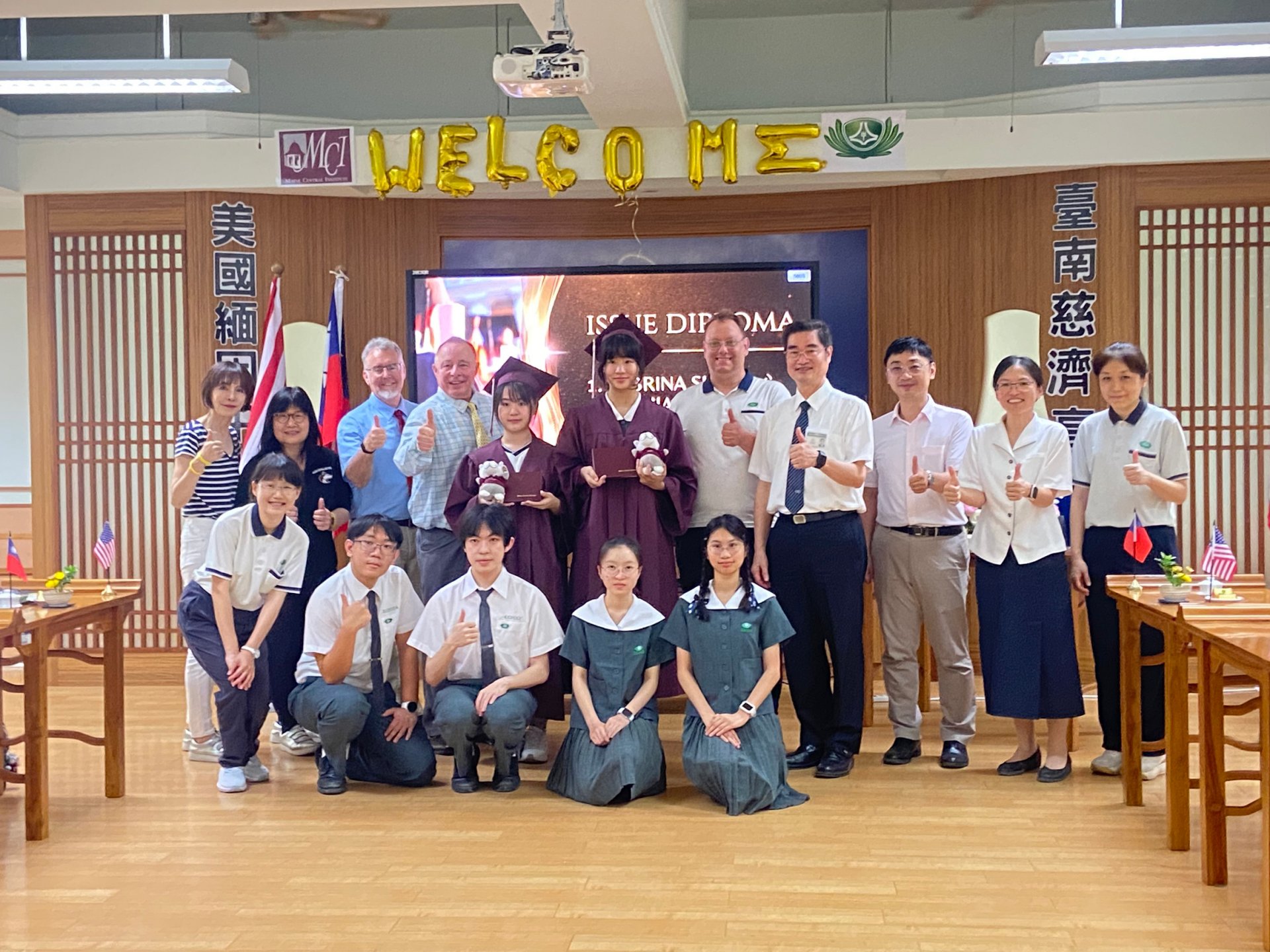 MCI雙聯畢業生身著學士服，手持證書，兩校代表共同合影，展現跨國教育成果。