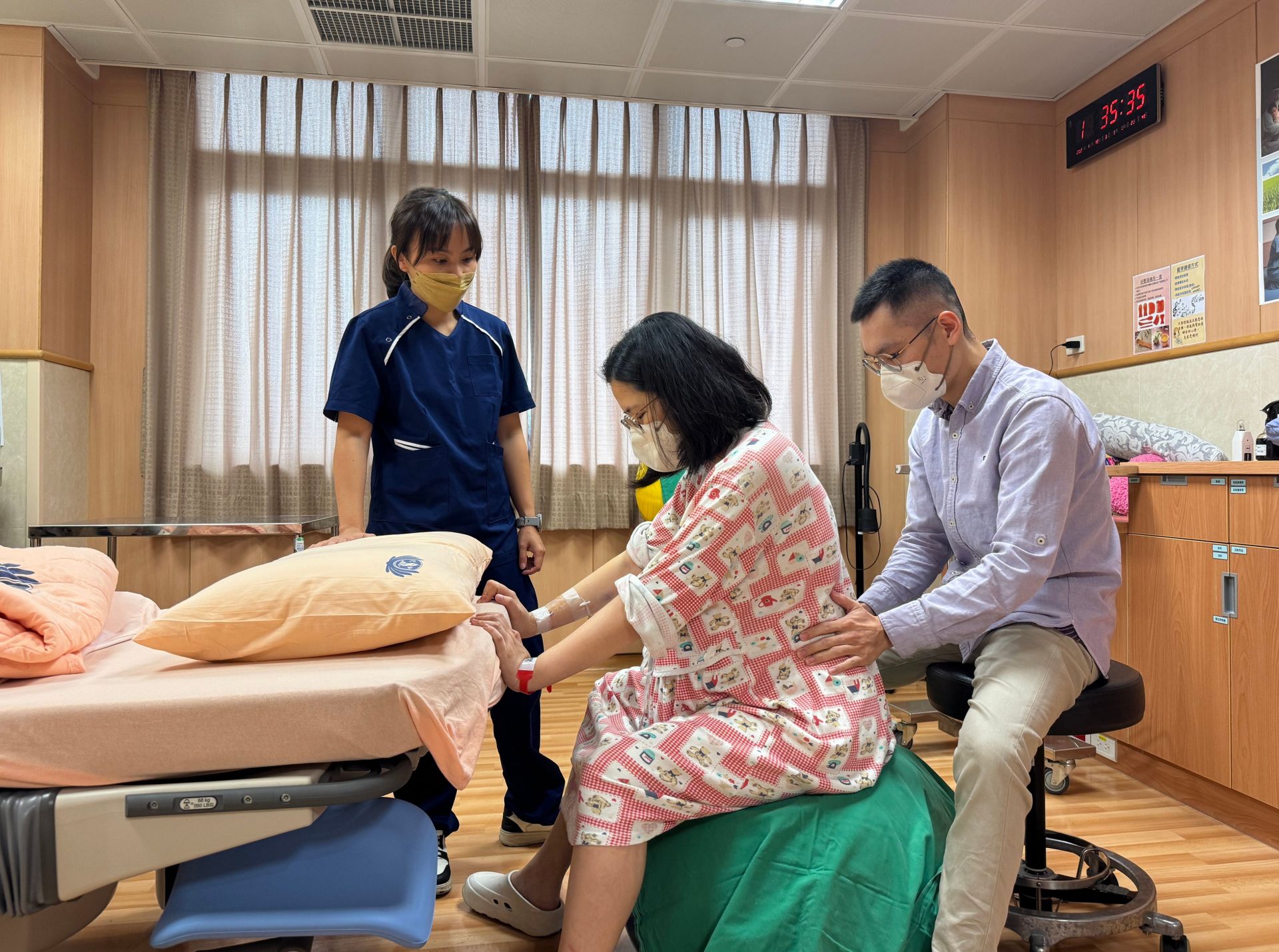 待產過程中，助產師（左）引導先生為太太進行助產動作，協助產婦舒緩陣痛不適。