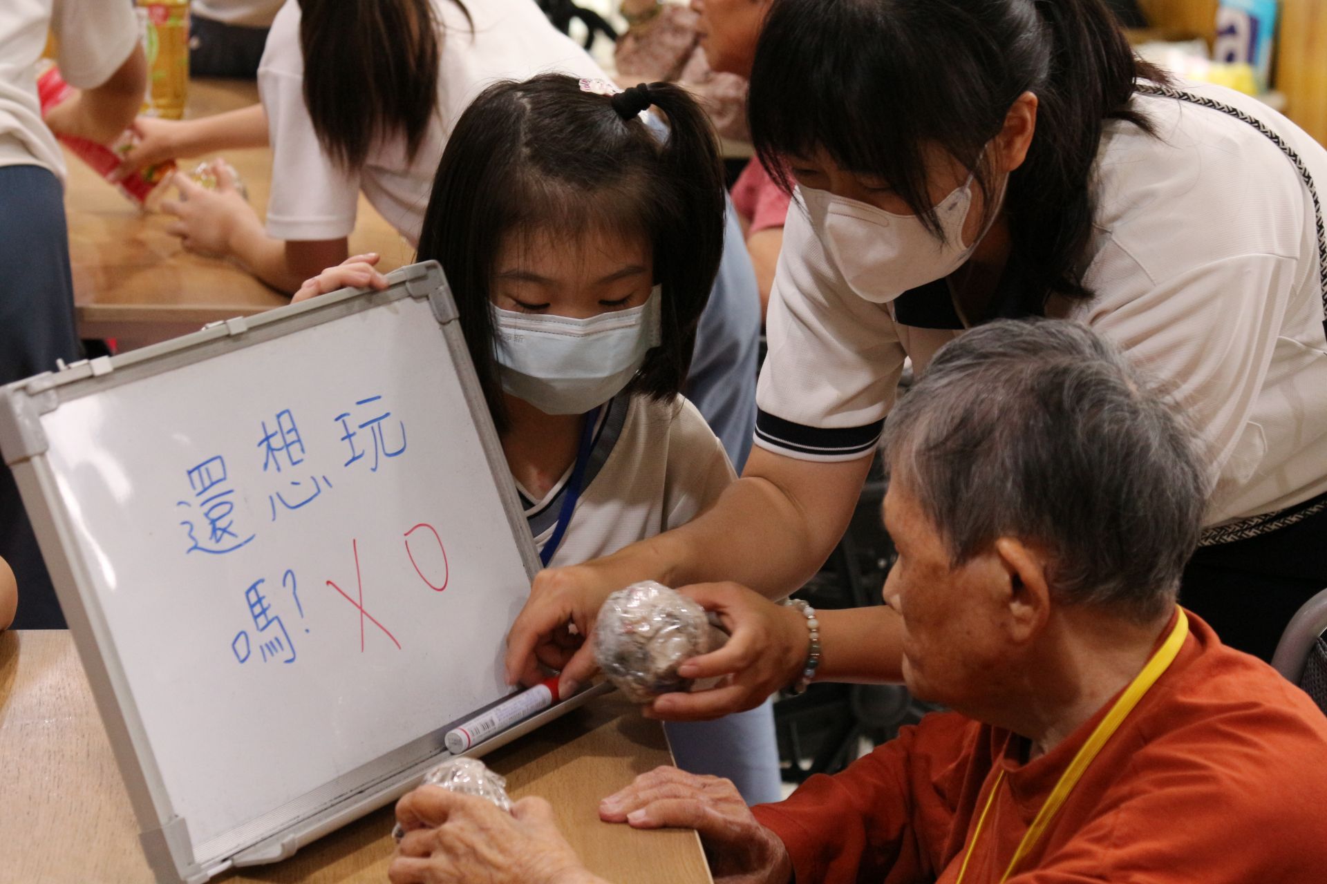 慈大附中學生志工與師長前往長期照顧中心，陪伴長輩度過溫暖的時刻。陪伴的阿嬤患有重聽，同學在盈珊老師引導下，使用白板與阿嬤對話