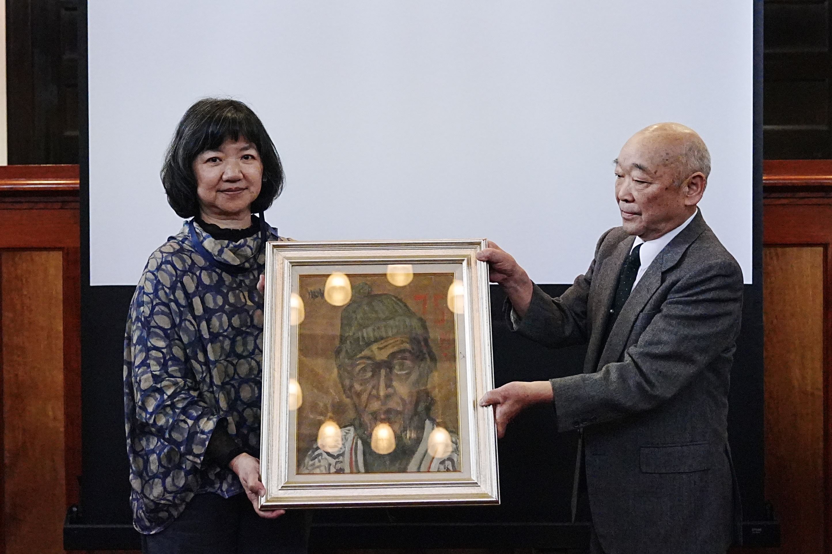 藤崎恒賴先生（右）捐贈佐伯信夫〈自畫像〉，由文化部政務次長李靜慧代表受贈