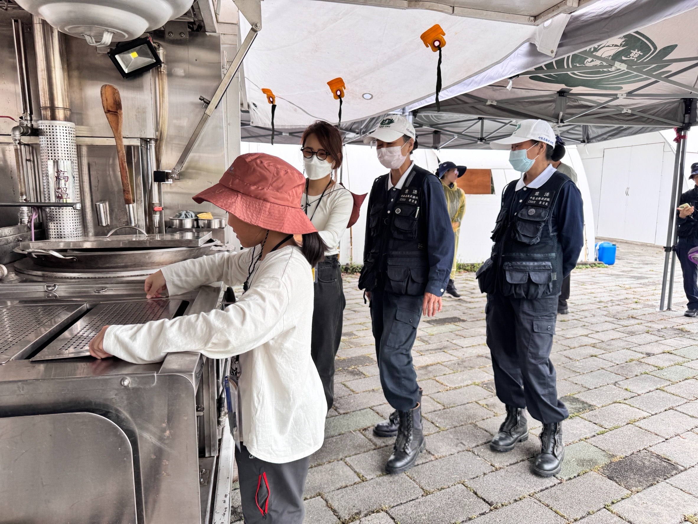 嚴同學（左一）體驗行動廚房時，很感興趣。她表示喜歡煮菜，在家裡也會幫忙煮