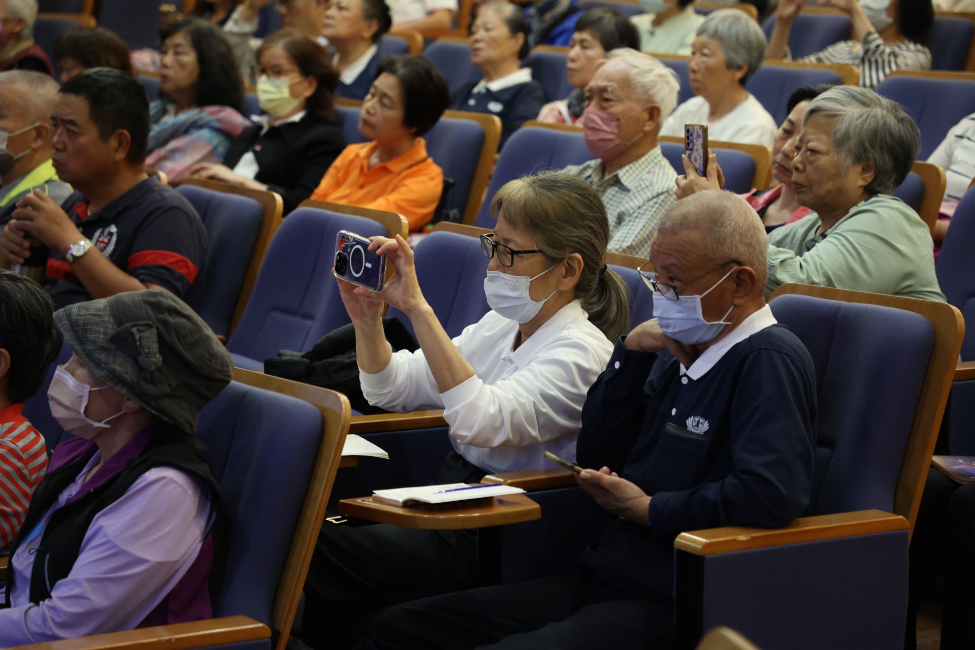 關心健康的長者們以手機或手寫記下重點。