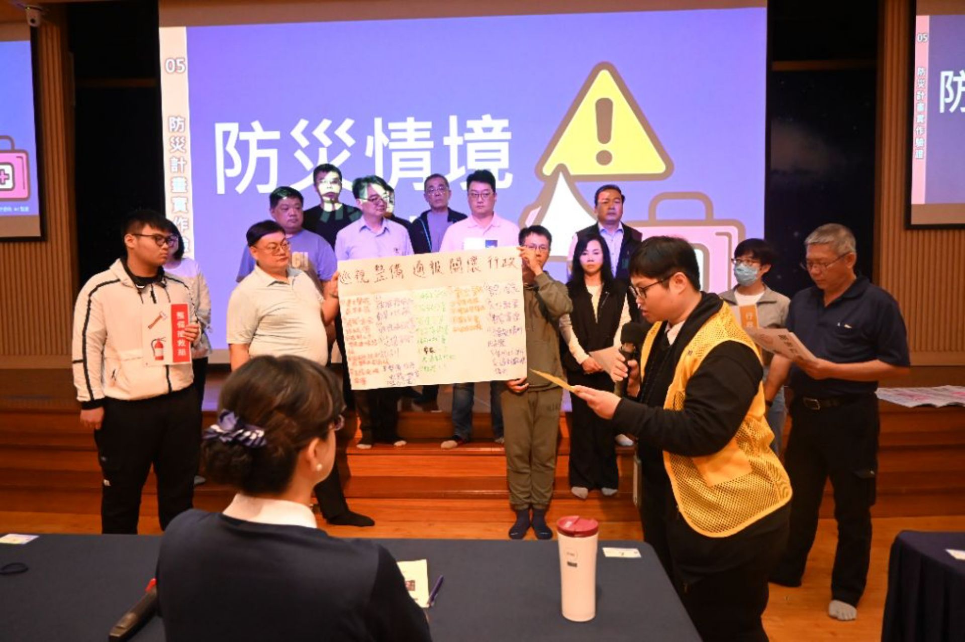 討論完成後，各組上台分享該組的社區防災計畫書。首先由指揮官敘述情境內容，再由各編組人力說明處置方式，最後由講師進行講評。