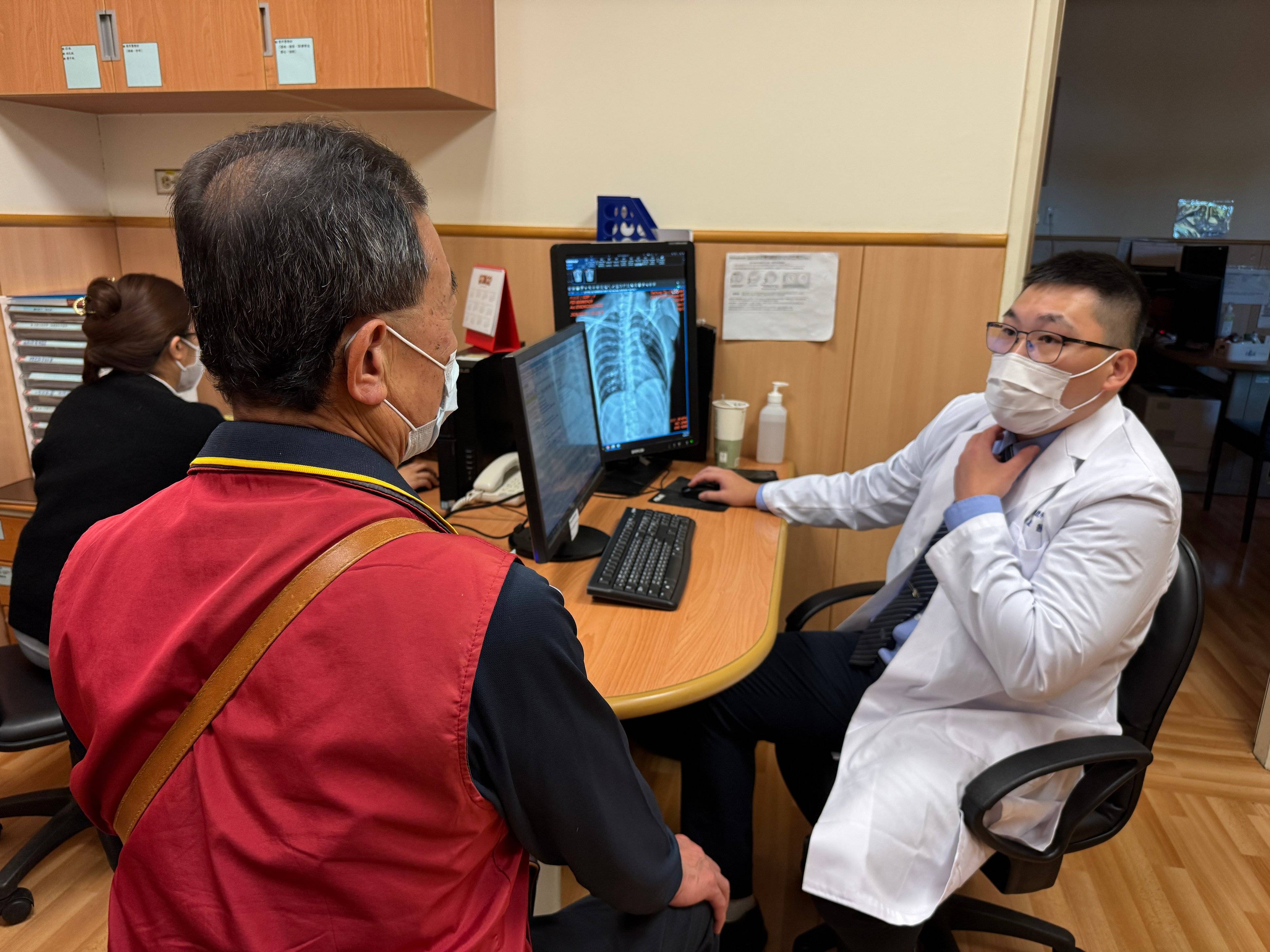 翁任康醫師（右）向林先生（左）詳細說明食道癌的病況，其清楚果斷的解說讓家屬宛如吃了「定心丸」。