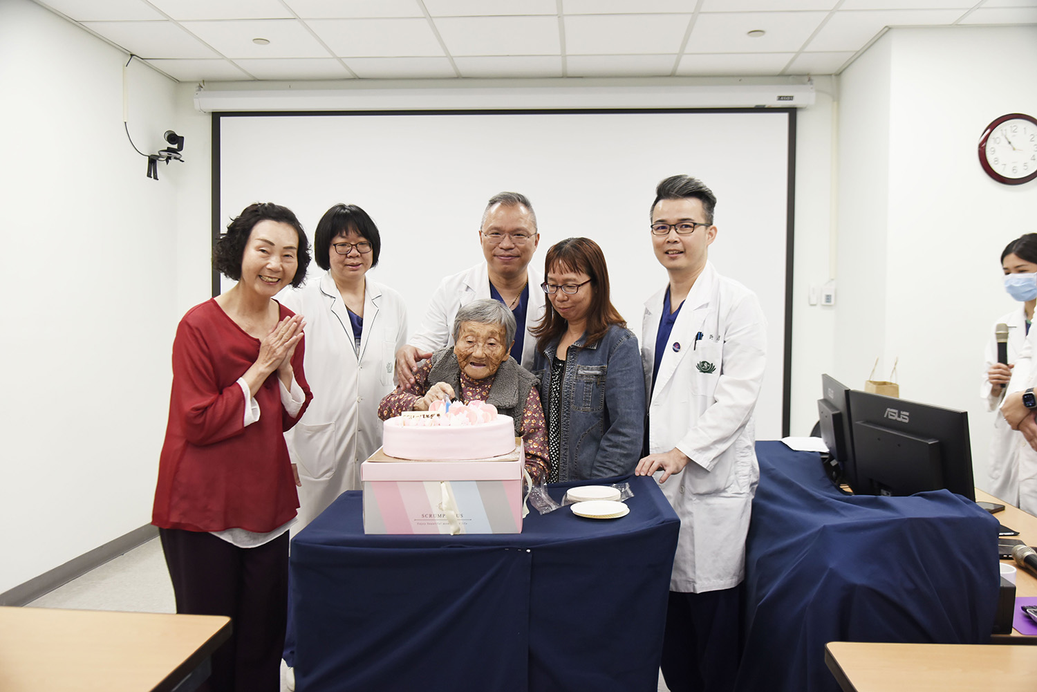 醫師與病人、家屬共同切蛋糕慶祝病房一週年。