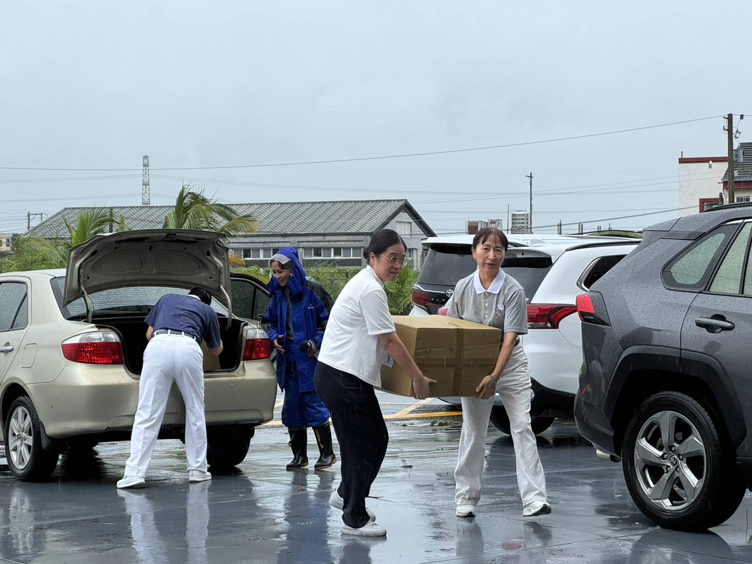 慈濟應變中心隨即動員屏東分會志工與社工冒雨整裝物資，以接龍方式迅速完成裝載。