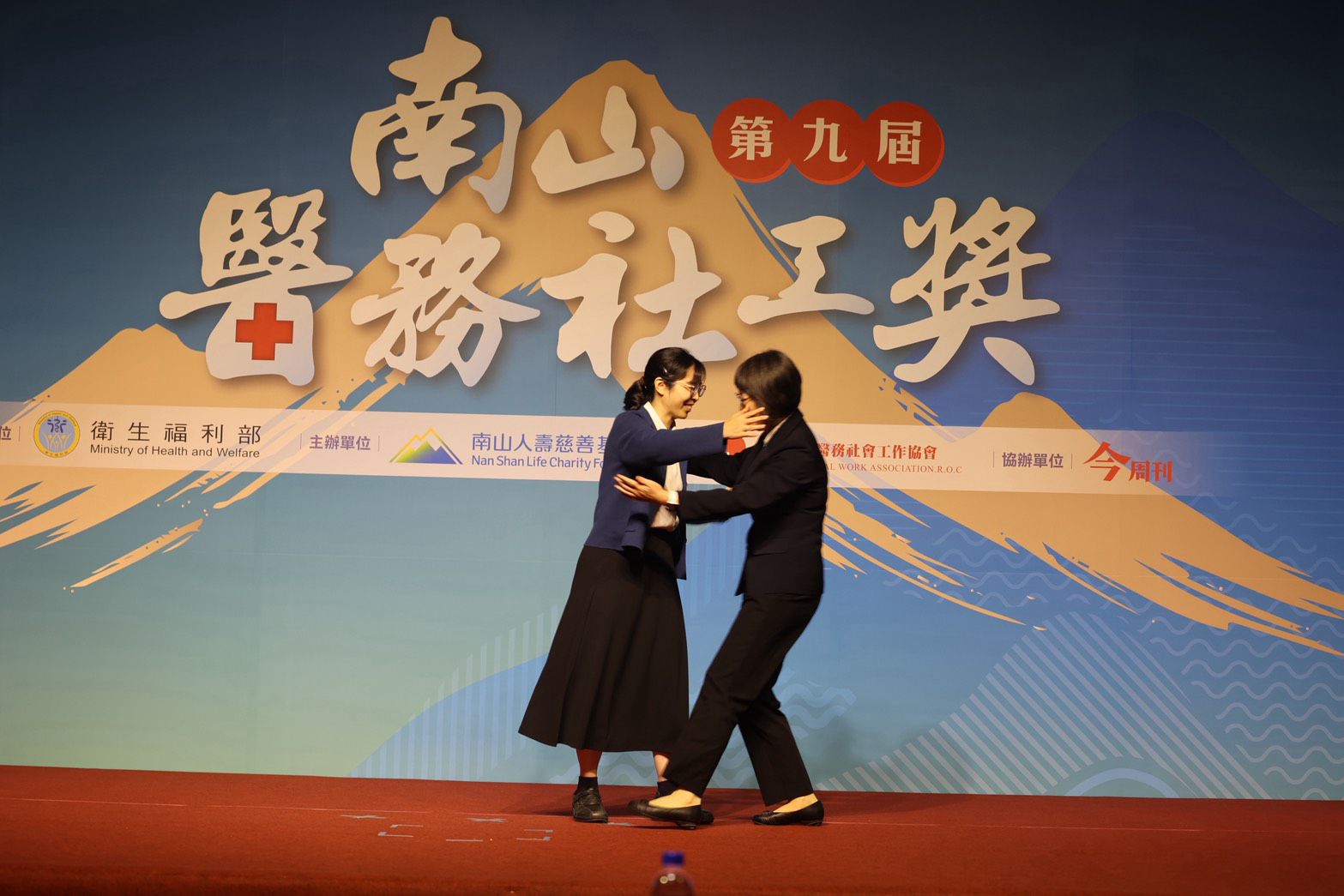 花蓮慈濟醫院醫務祕書吳雅汝醫師擔任頒獎介紹人,他感謝卓依蒨醫務社工師,在高壓的重症醫療歷程裡,不但接住了病人和家屬,也接住了所有醫護同仁。兩人緊緊擁抱。