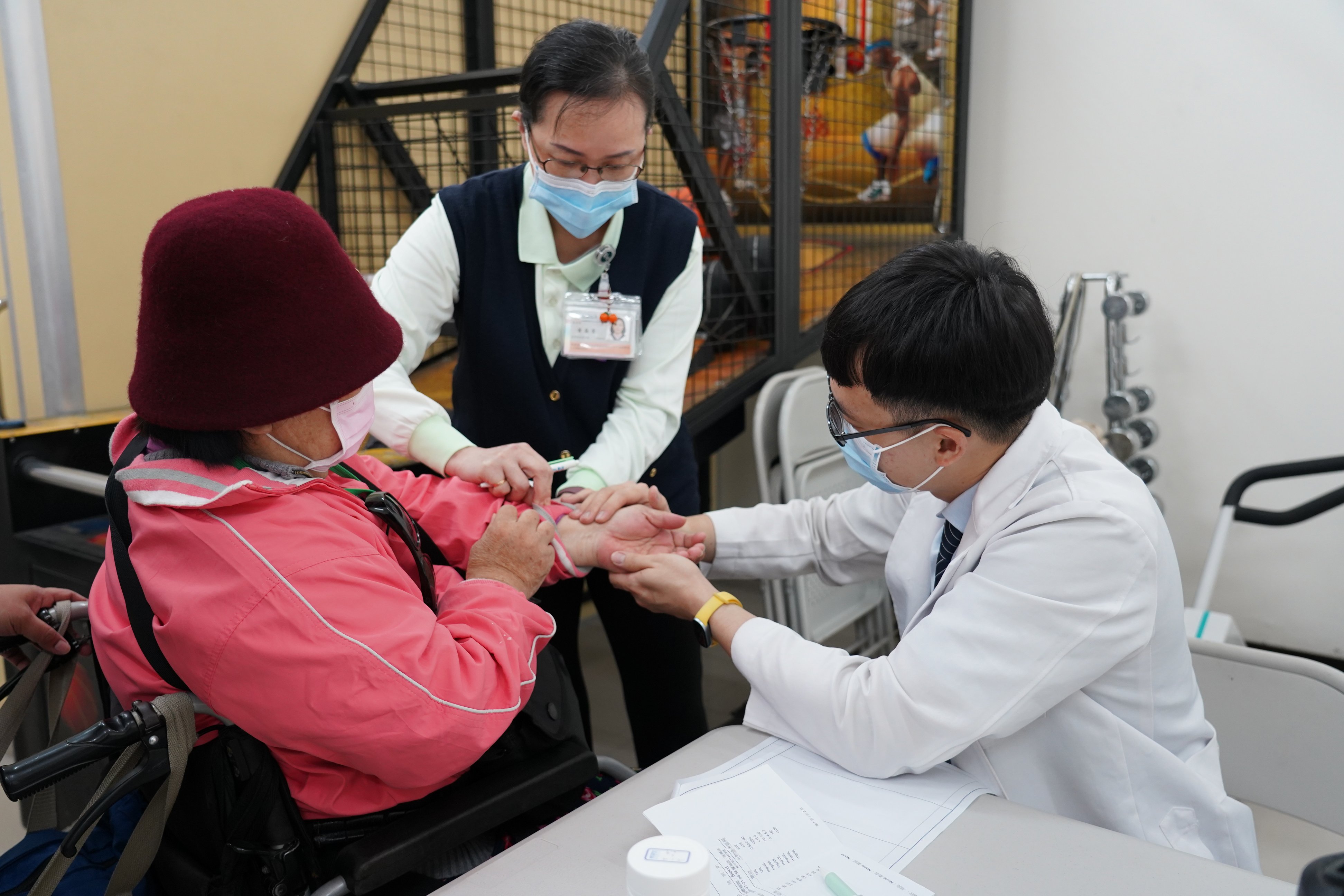 中醫部醫師洪正君(右)透過脈診與針灸為傷友調理體質,協助舒緩因脊髓損傷帶來的肢體僵硬與不適。