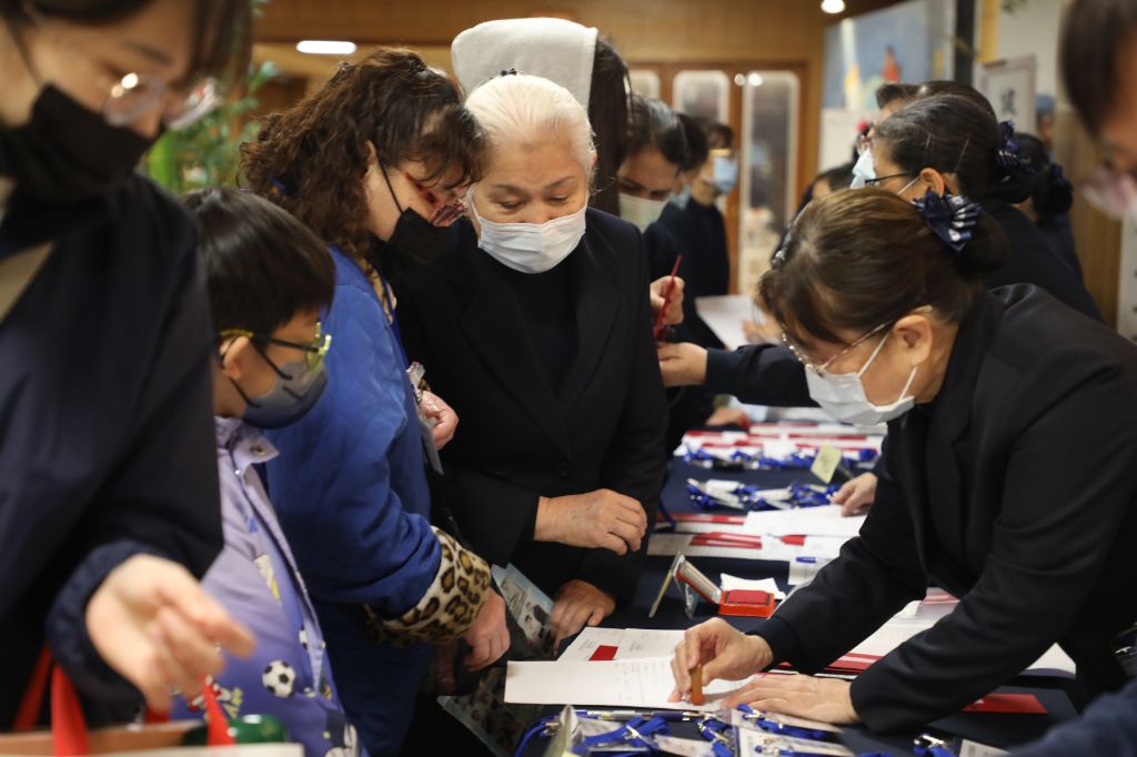 慈濟志工陪伴照顧戶完成報到並領取慈善物資卡。