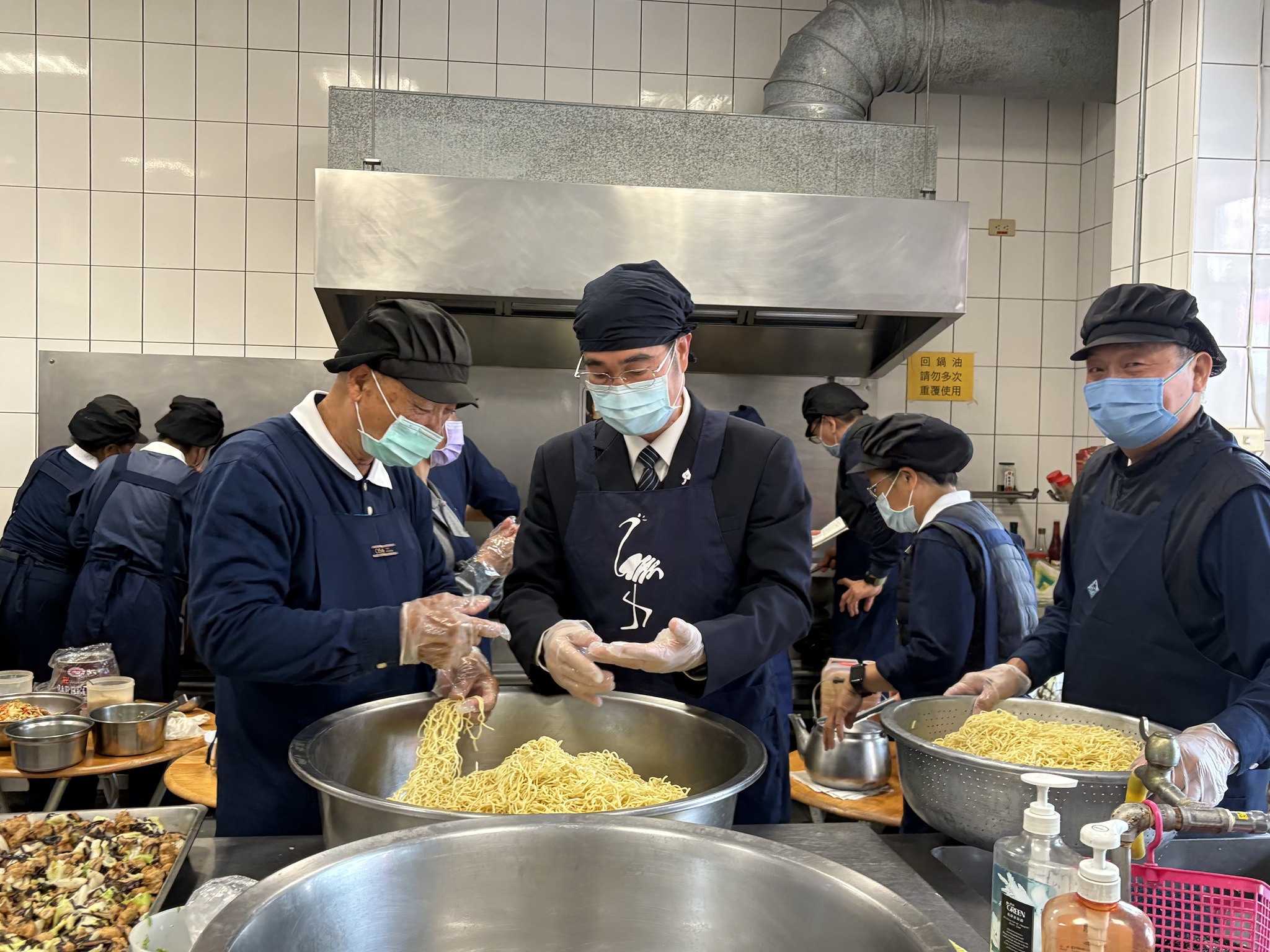 姚智化校長在香機組協助準備美食佳餚。