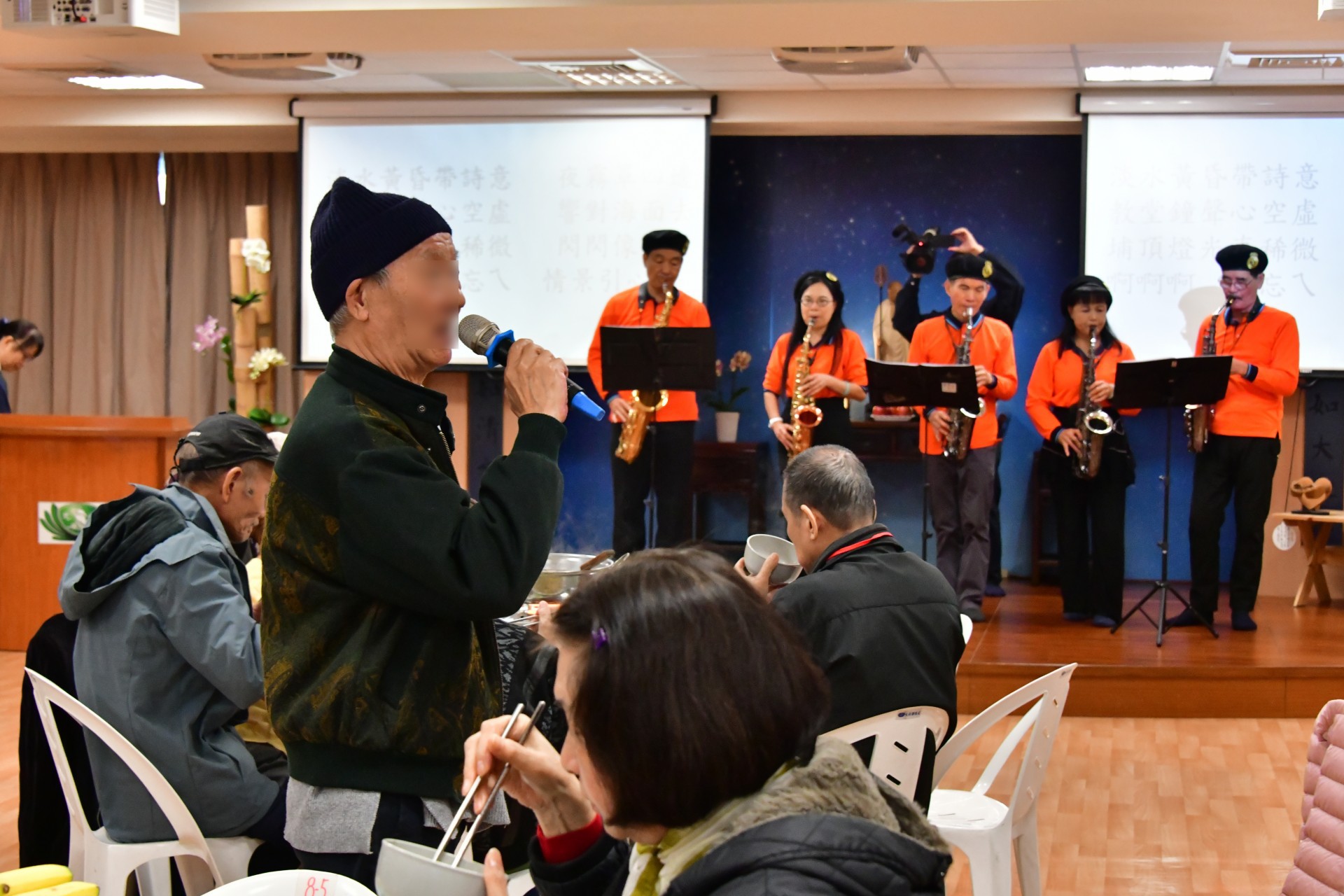 長者們享用圍爐美味的蔬食，喜好歌唱的長者跟著樂隊演奏旋律唱著台語老歌。