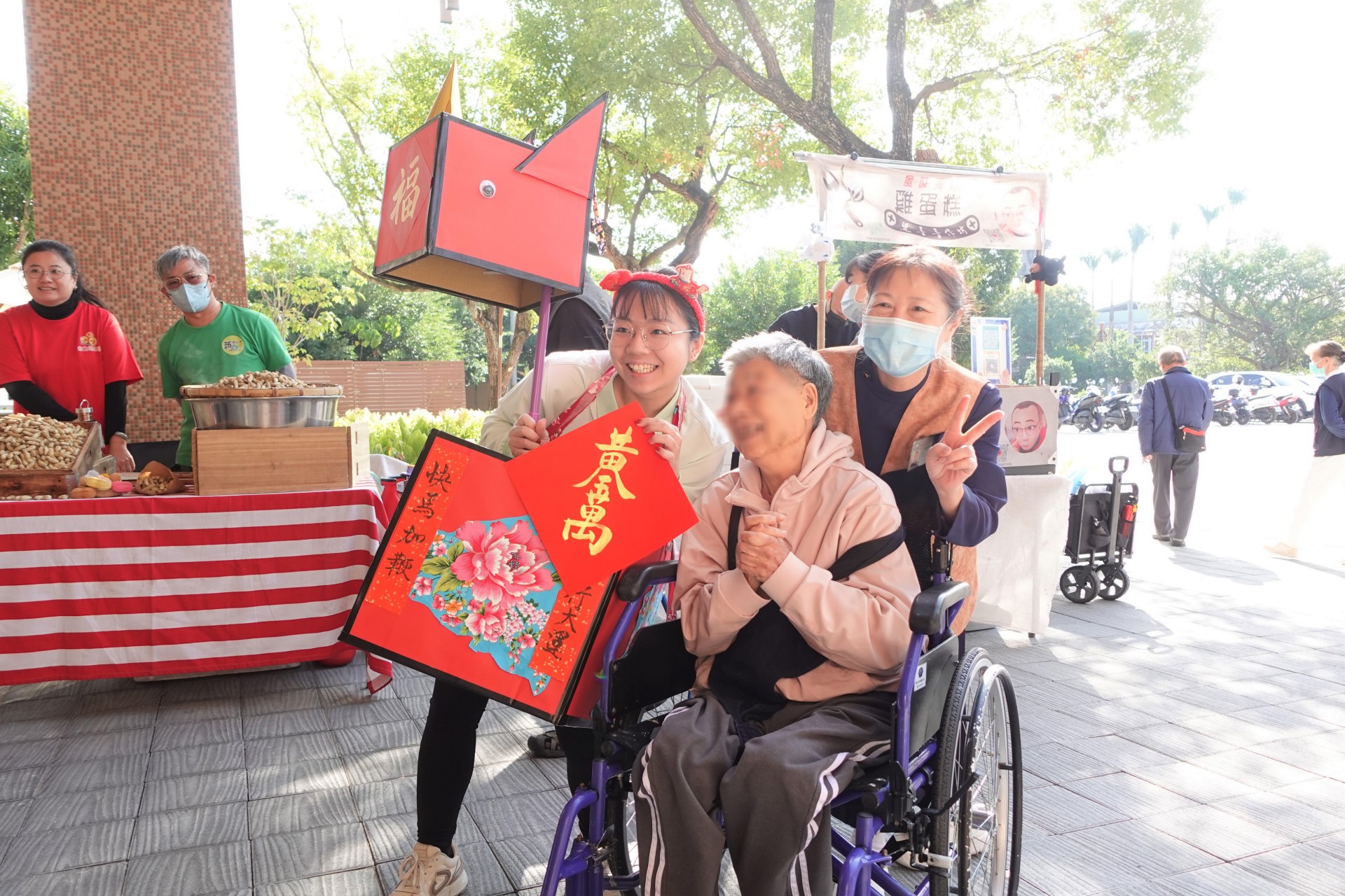 機構人員穿著喜氣的「福氣馬」造型裝飾，帶住民長輩逛街採買、發送春聯給各攤位。