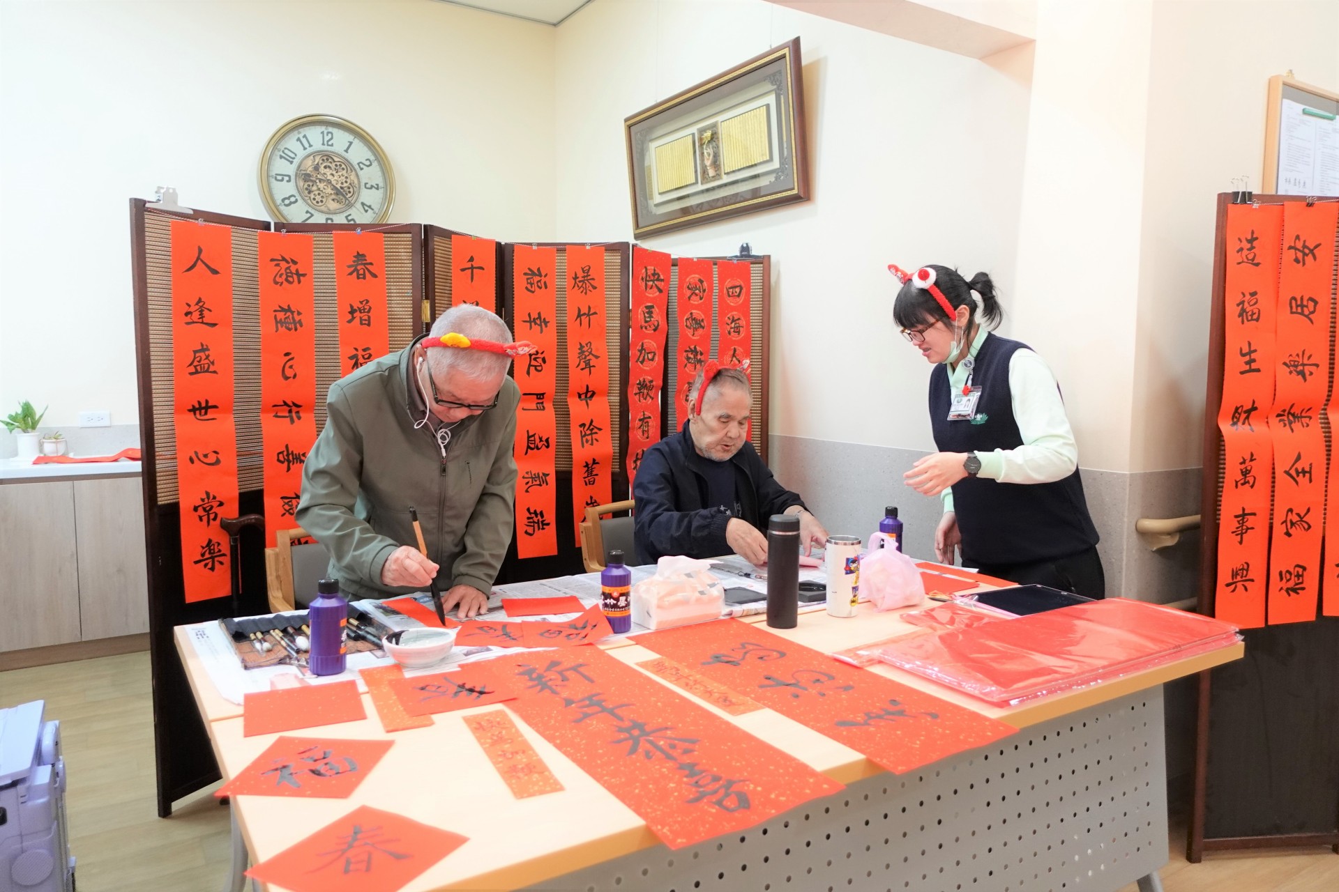 張爺爺(左二)過去是鄰里間知名的書法好手，他展現筆墨功力，神采奕奕的寫吉祥話。