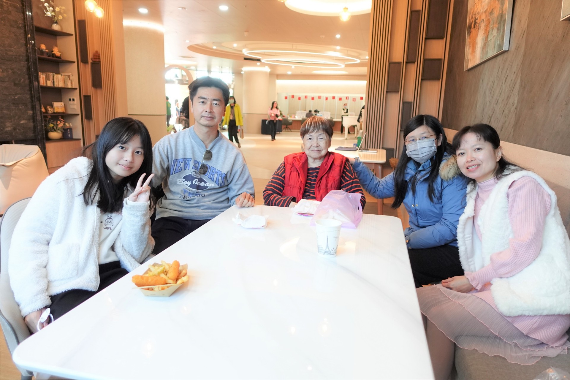 75歲林奶奶(左三)與兒子(左二)一家人聚在一起用餐點。