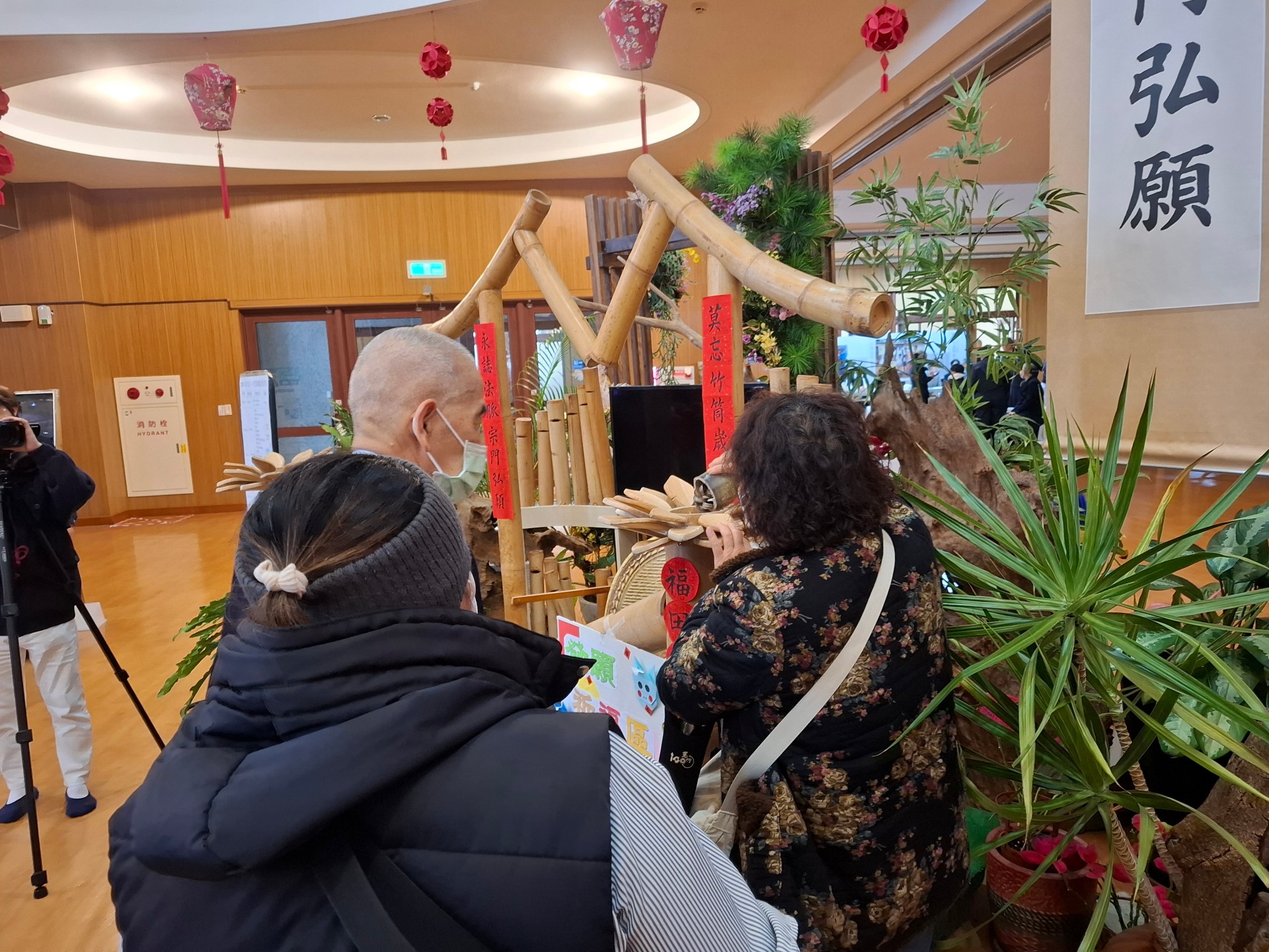 慈濟志工鄧金水引導大家參與竹筒回娘家活動