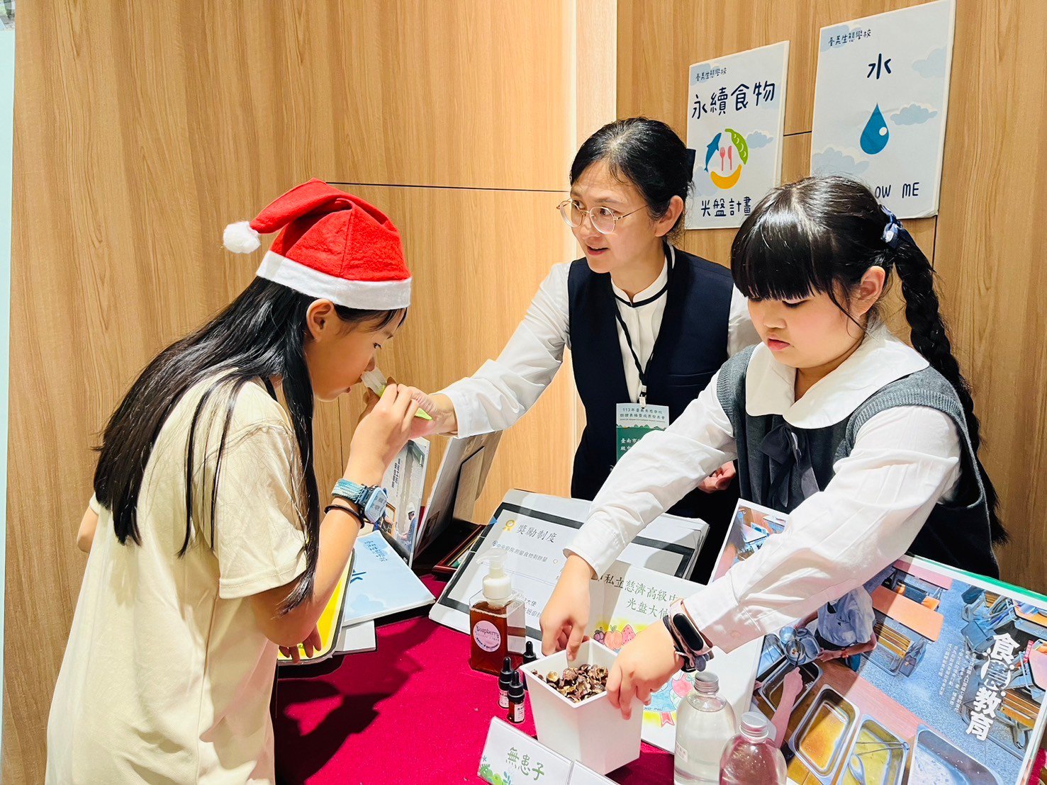 顏秀雯主任(中)帶領學生透過實作與互動展示，讓社會大眾更認識環保行動的具體成果。