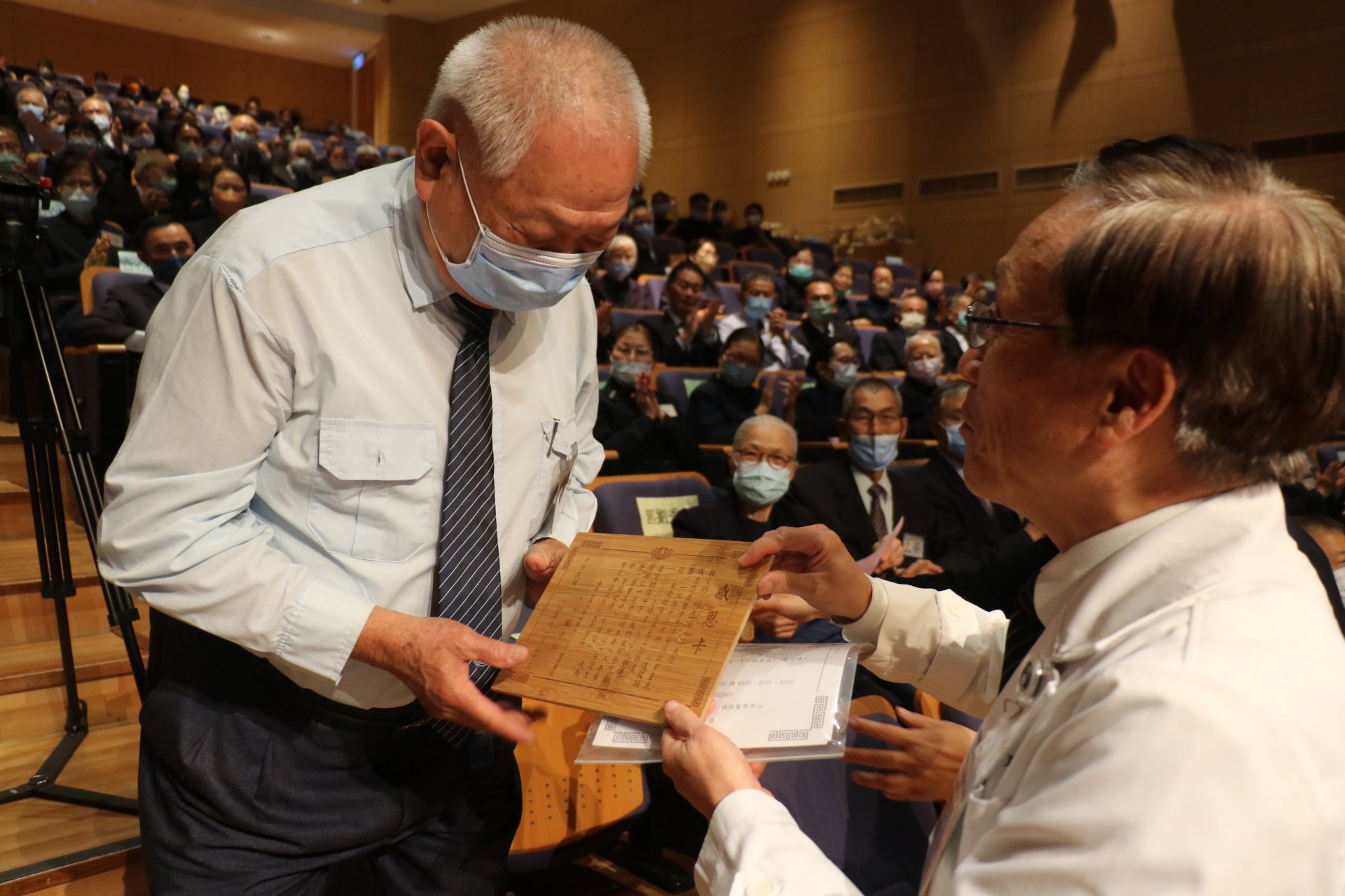 簡守信院長（右）表揚服務時數突破一萬小時的楊立川（左）。楊立川雖年邁拄著拐杖仍堅持服務，精神令人感佩。