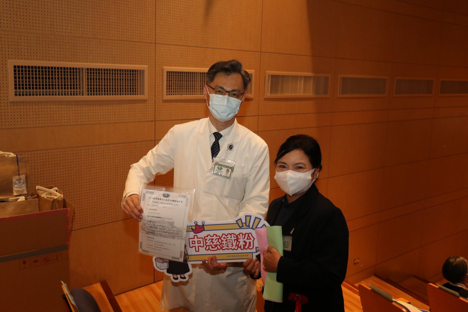 「誰最瞭解台中慈院」互動遊戲選出優勝志工，由外科部主任鄭紹彬（左）送上高階影像檢查資格，回饋志工的付出。
