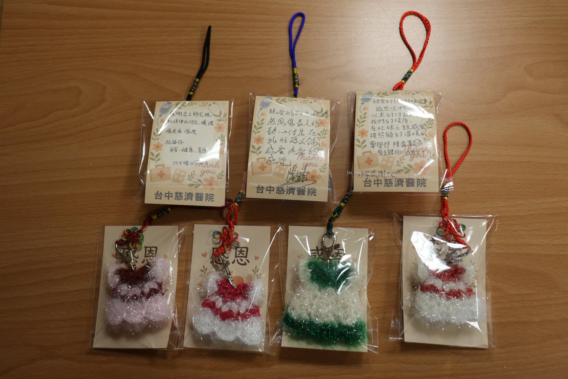 今年結緣品充滿溫度，由醫師眷屬親手縫製的「絲瓜布吊飾」寓意情誼絲絲相連，搭配全院同仁手寫感恩卡，傳達醫療團隊的誠摯謝意。