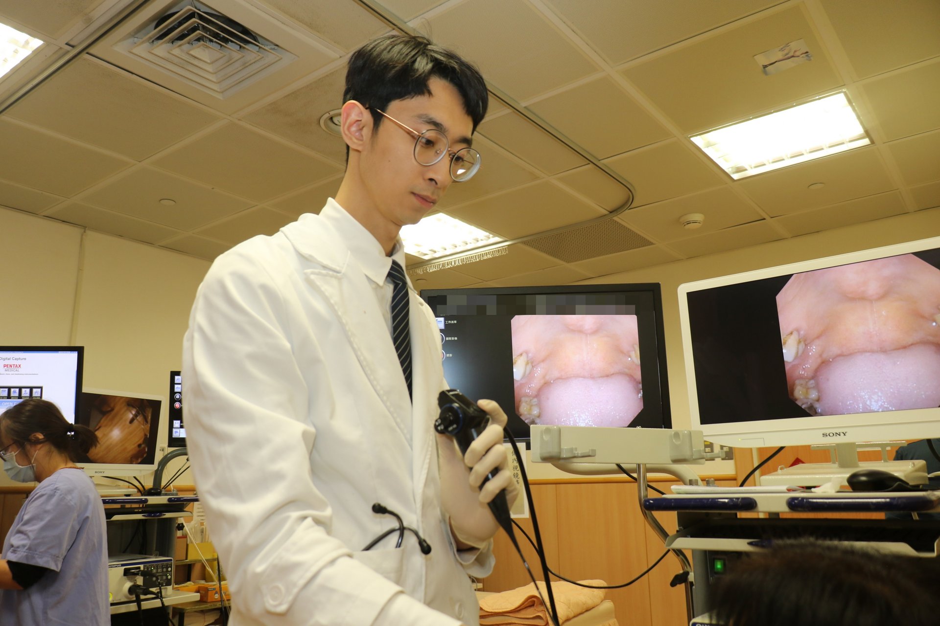 陳郁杭醫師為病人檢查口咽。