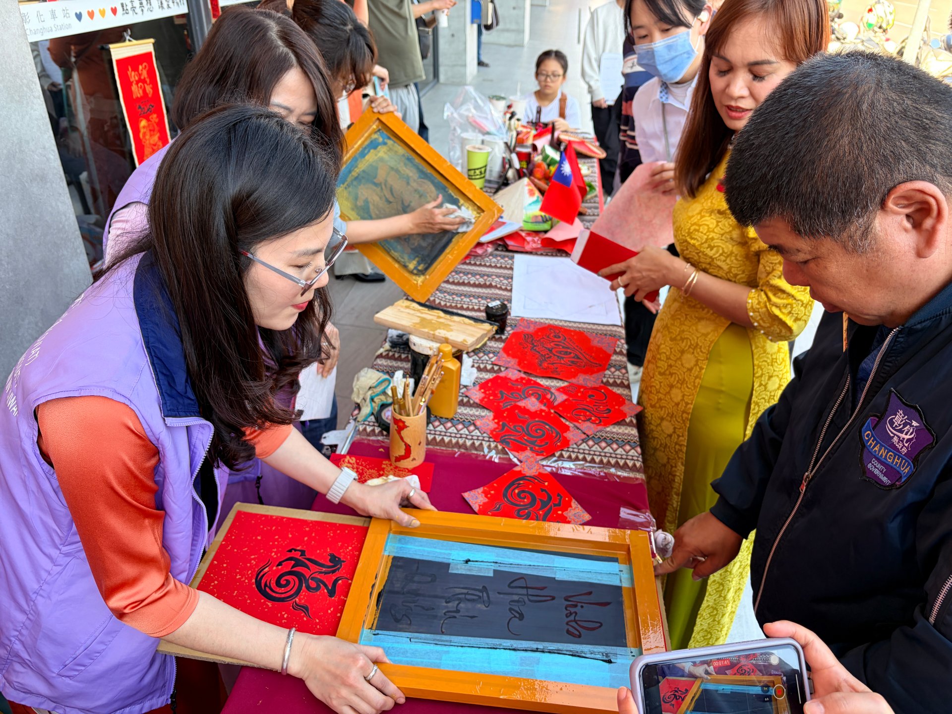 在越南僑裔高階人才在臺總會新住民夥伴的引導下，手持刮板輕輕一刷，年畫圖案隨即呈現。