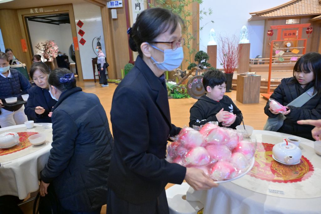 一樓福慧廳小圓桌的志工邀請大家入座，備有糖果、奉茶、壽桃以及平安粥，祝福日日吉祥平安。