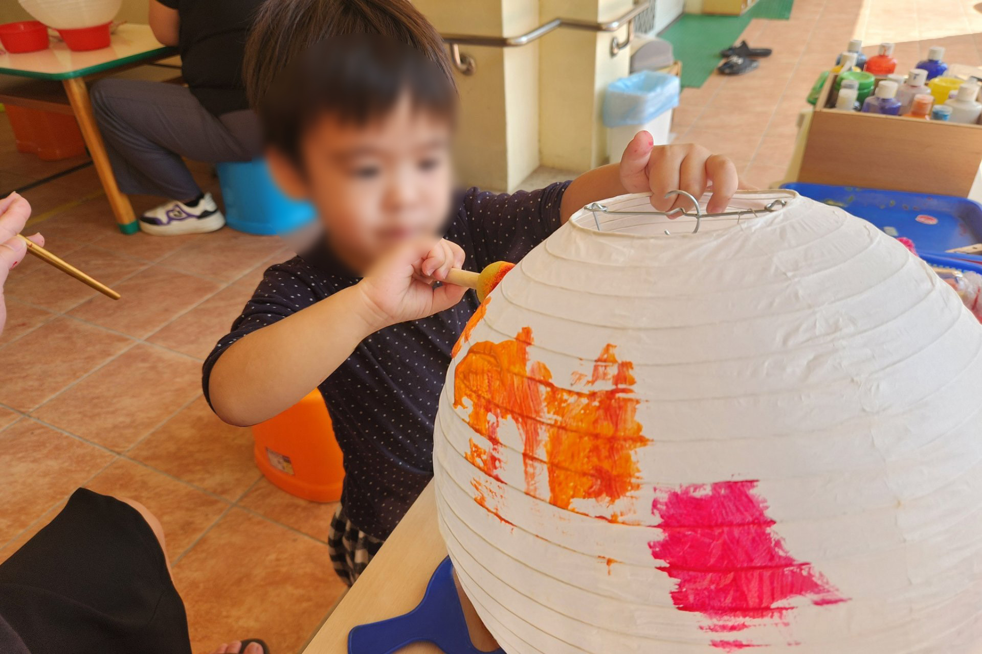 小安使用顏料在燈籠面上色