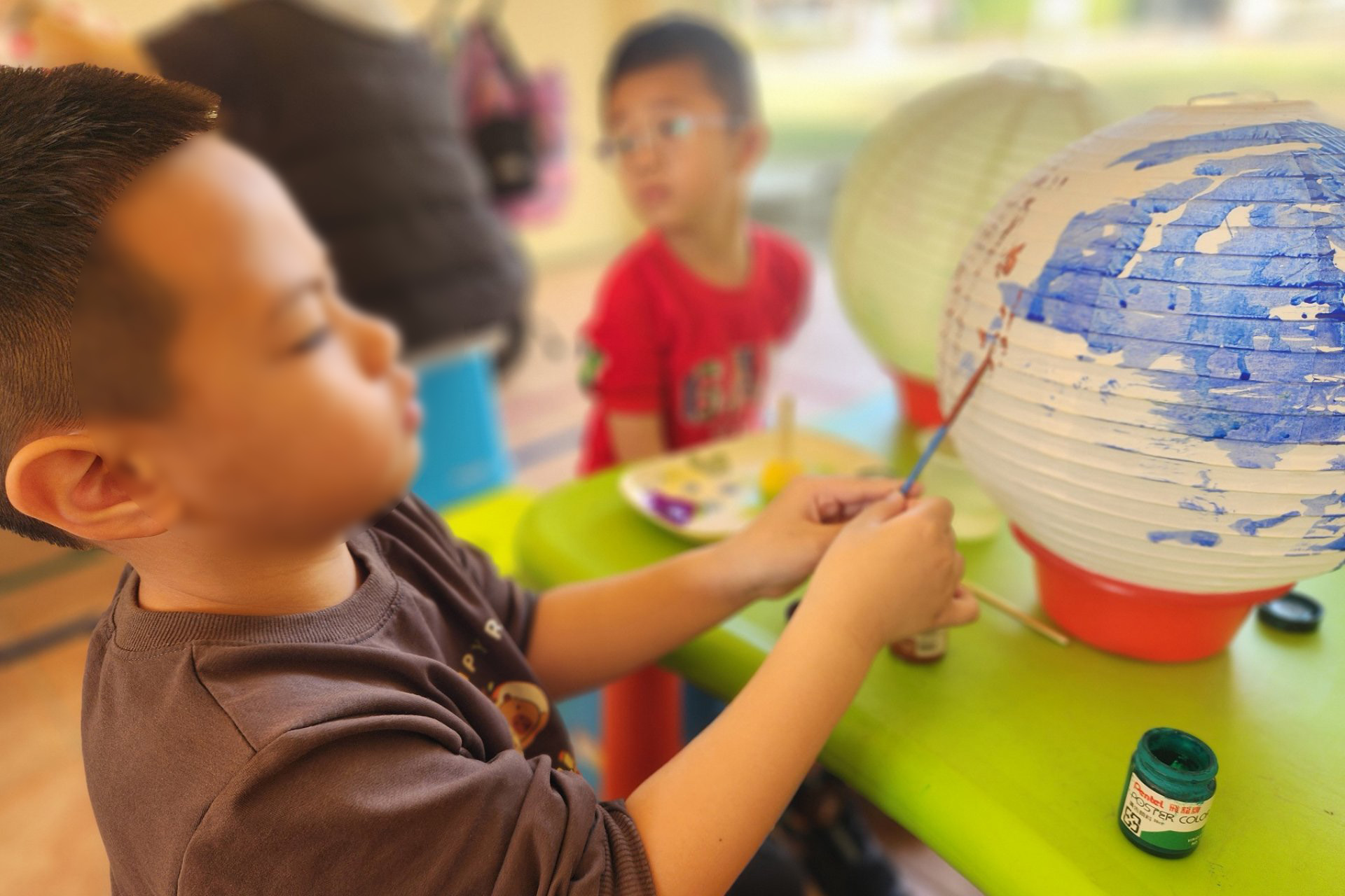 幼童使用顏料在燈籠面上色
