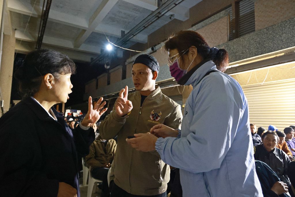 班長阿龍(中)不斷地穿梭在志工跟船員間，確認發放的數量及程序。他說，在海上很冷，收到外套一定會穿起來，因為它讓我感到溫暖、更安心。