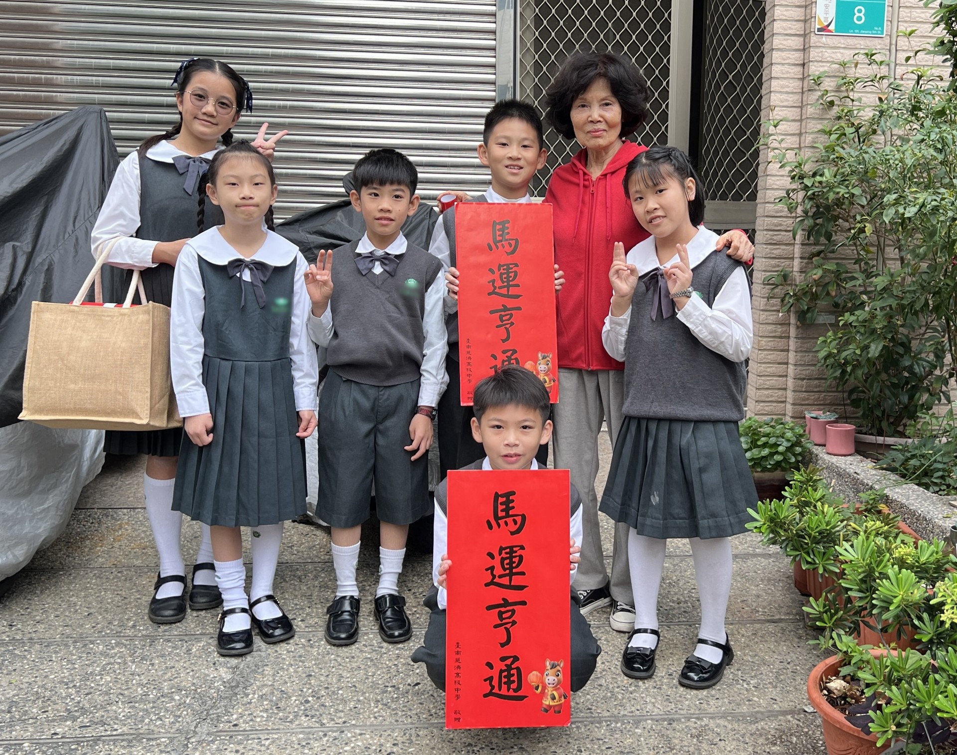 送出祝福，收獲笑容！學生們帶著春聯走訪社區，鄰居熱情合影。