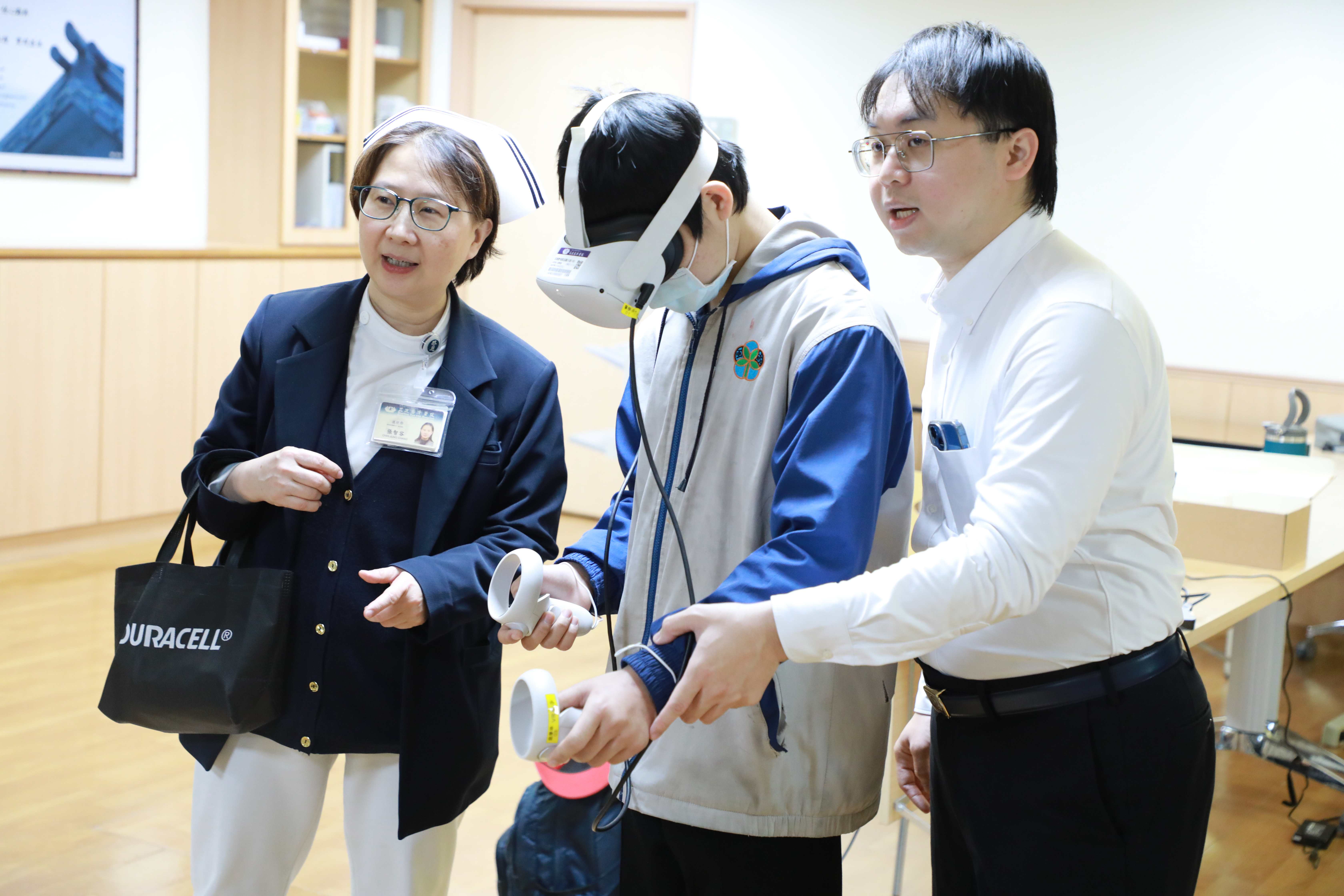 教學部陳王軒指導同學操作VR教具,護理部張智容督導也在旁關心。
